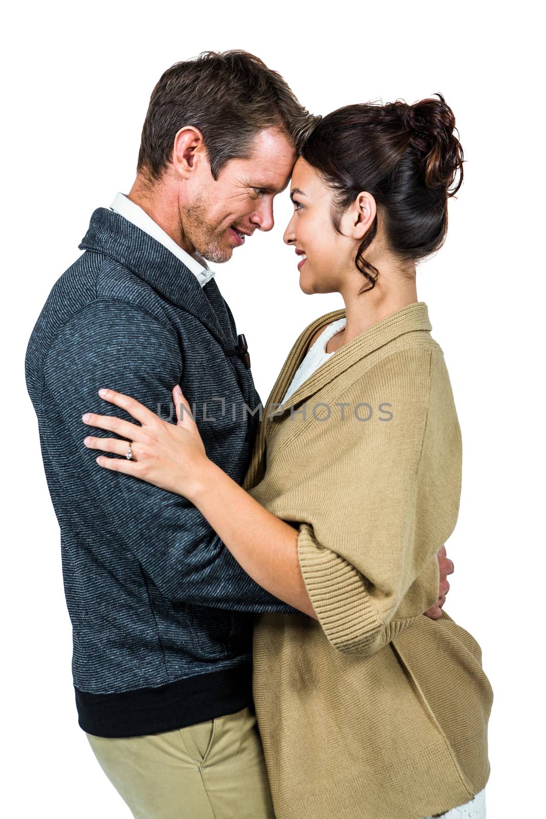 Side view of romantic couple hugging against white background