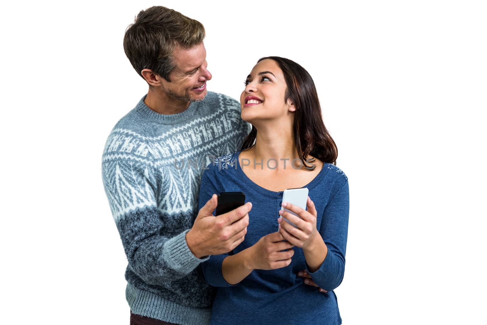 Happy romantic couple with mobile phone standing against white background