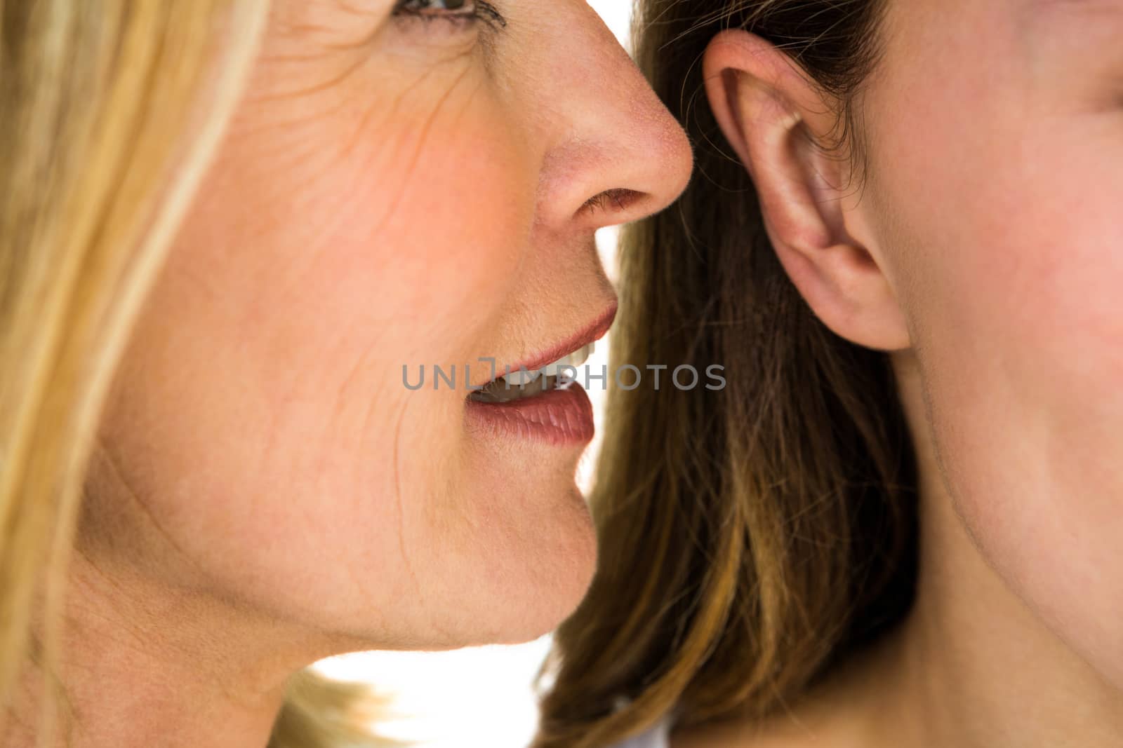 mother whispering something to her daughter
