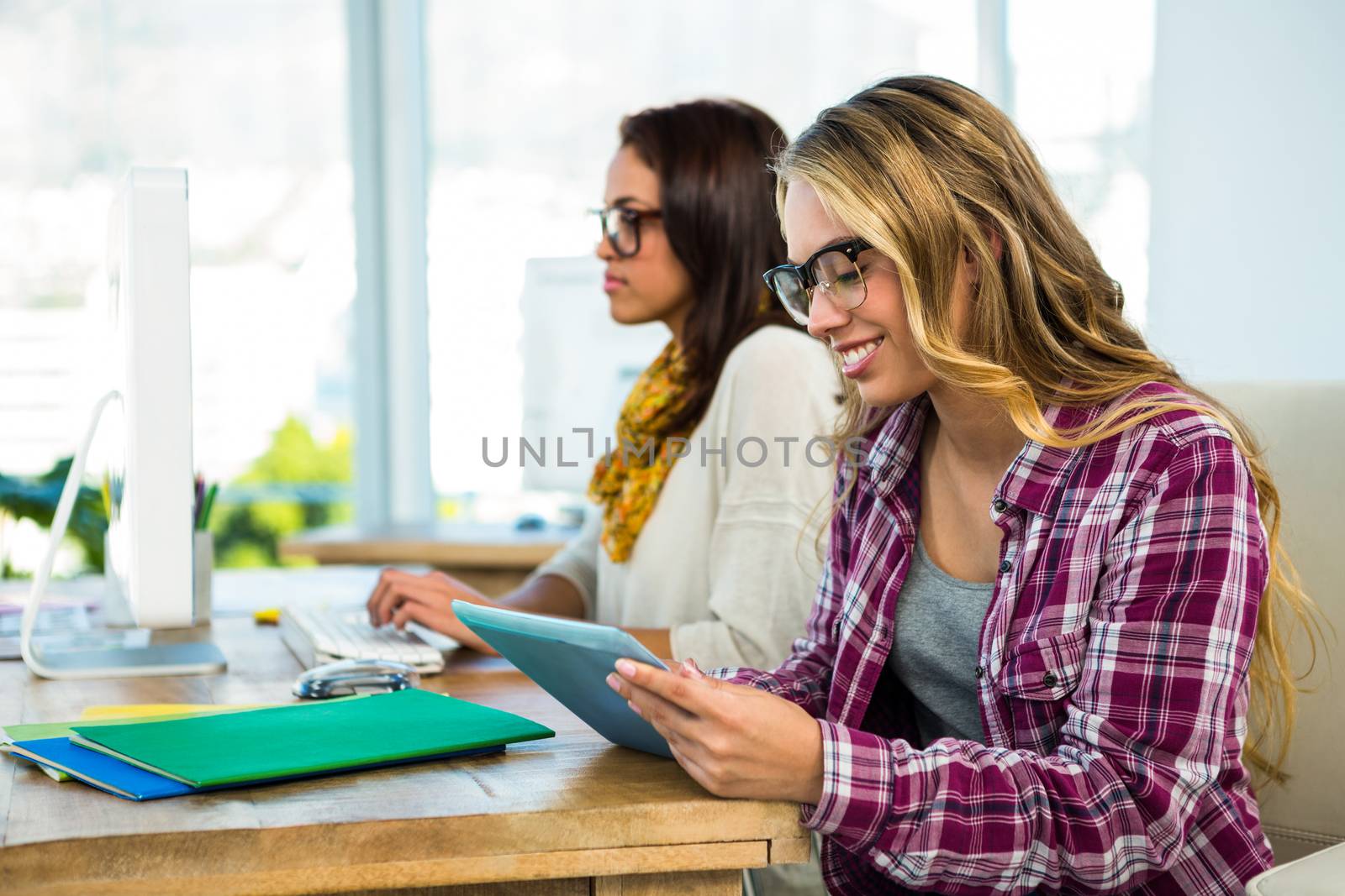 Two girls work at office by Wavebreakmedia