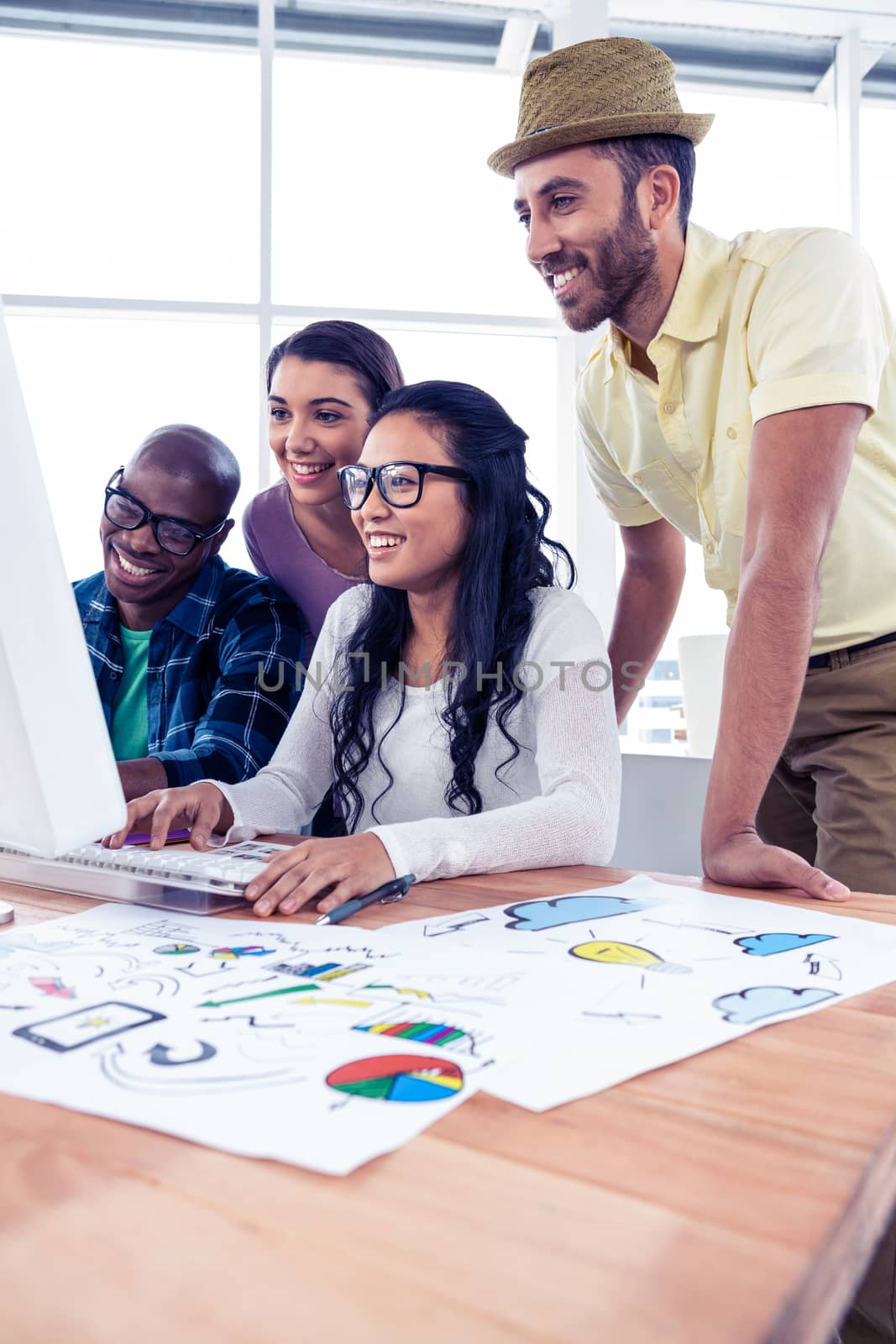 Happy business team working over computer at creative office