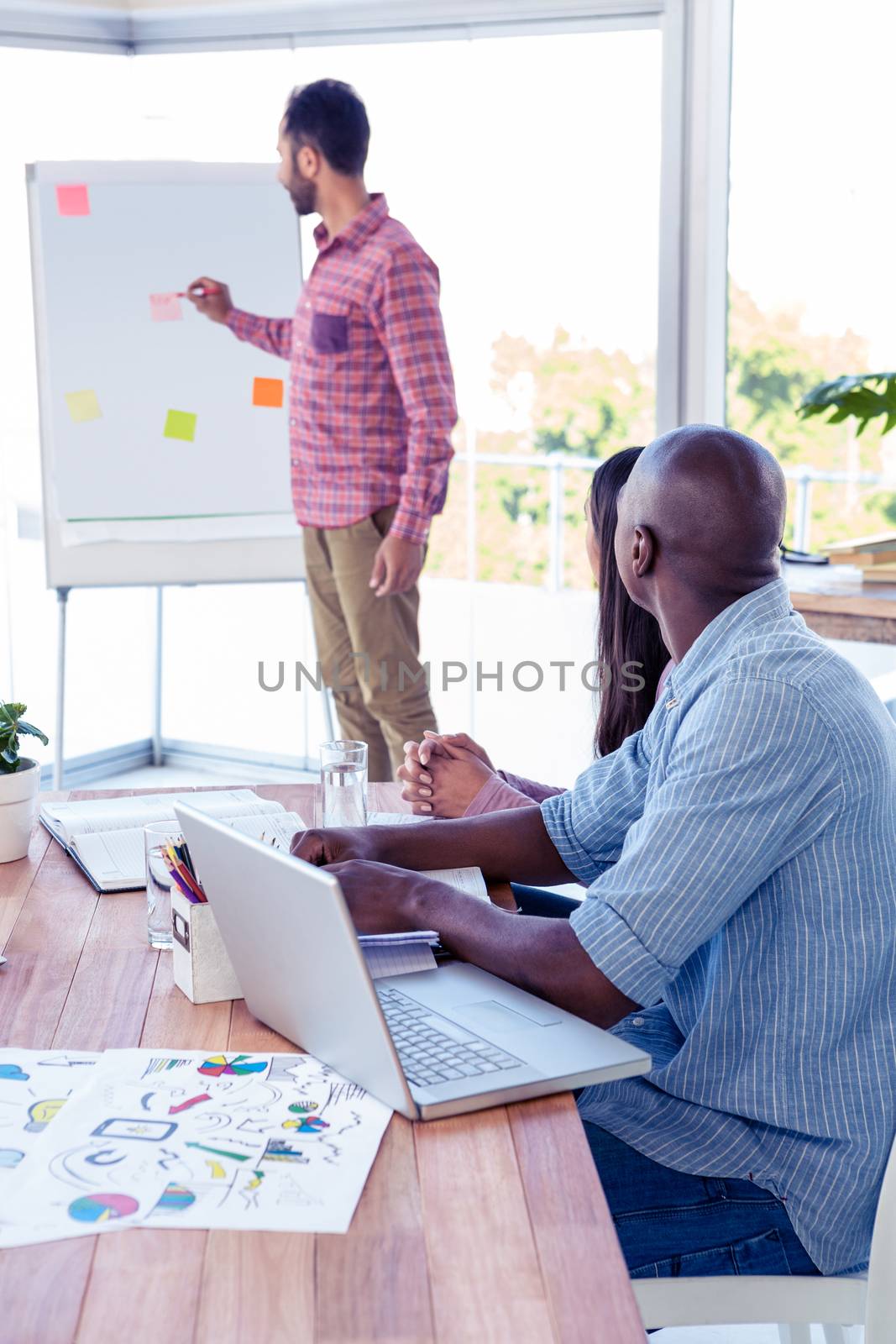 Young businessman giving presentation in creative office