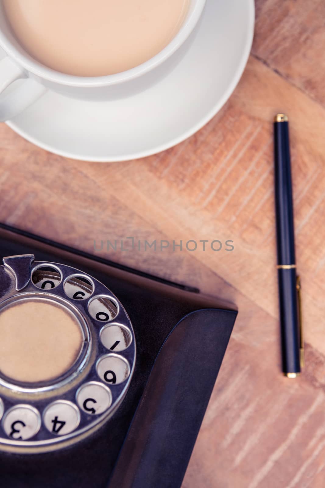 Coffee with old land line and pen  by Wavebreakmedia