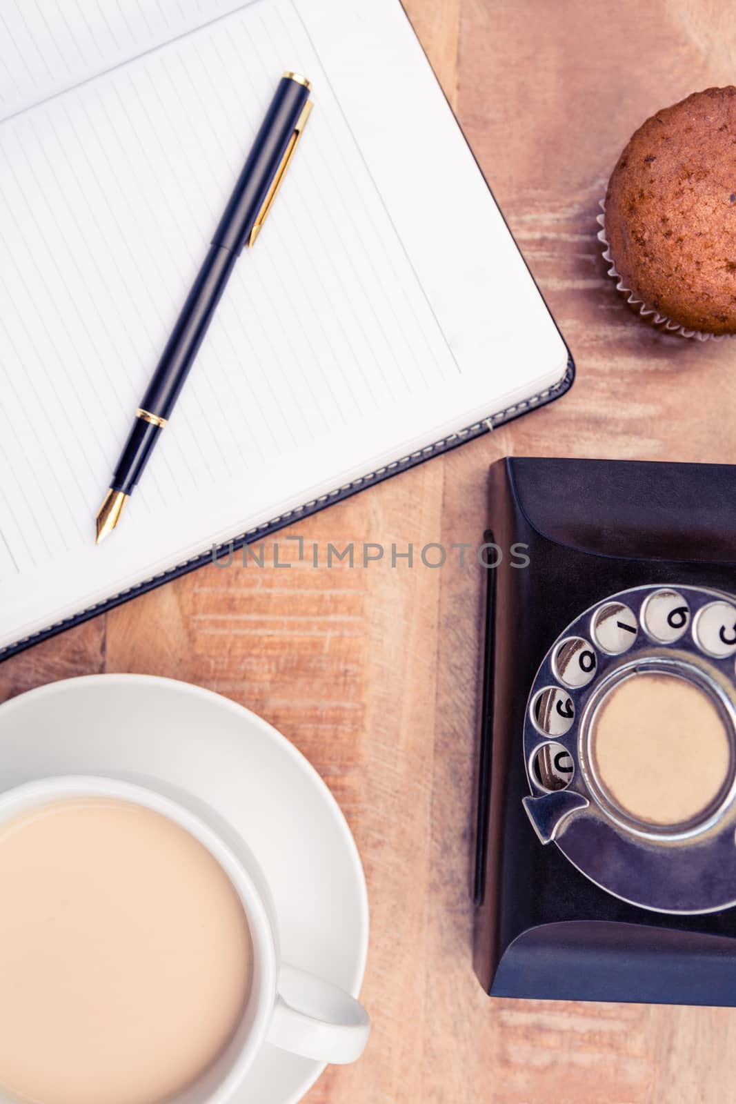 Close-up of coffee with old land line and book on table