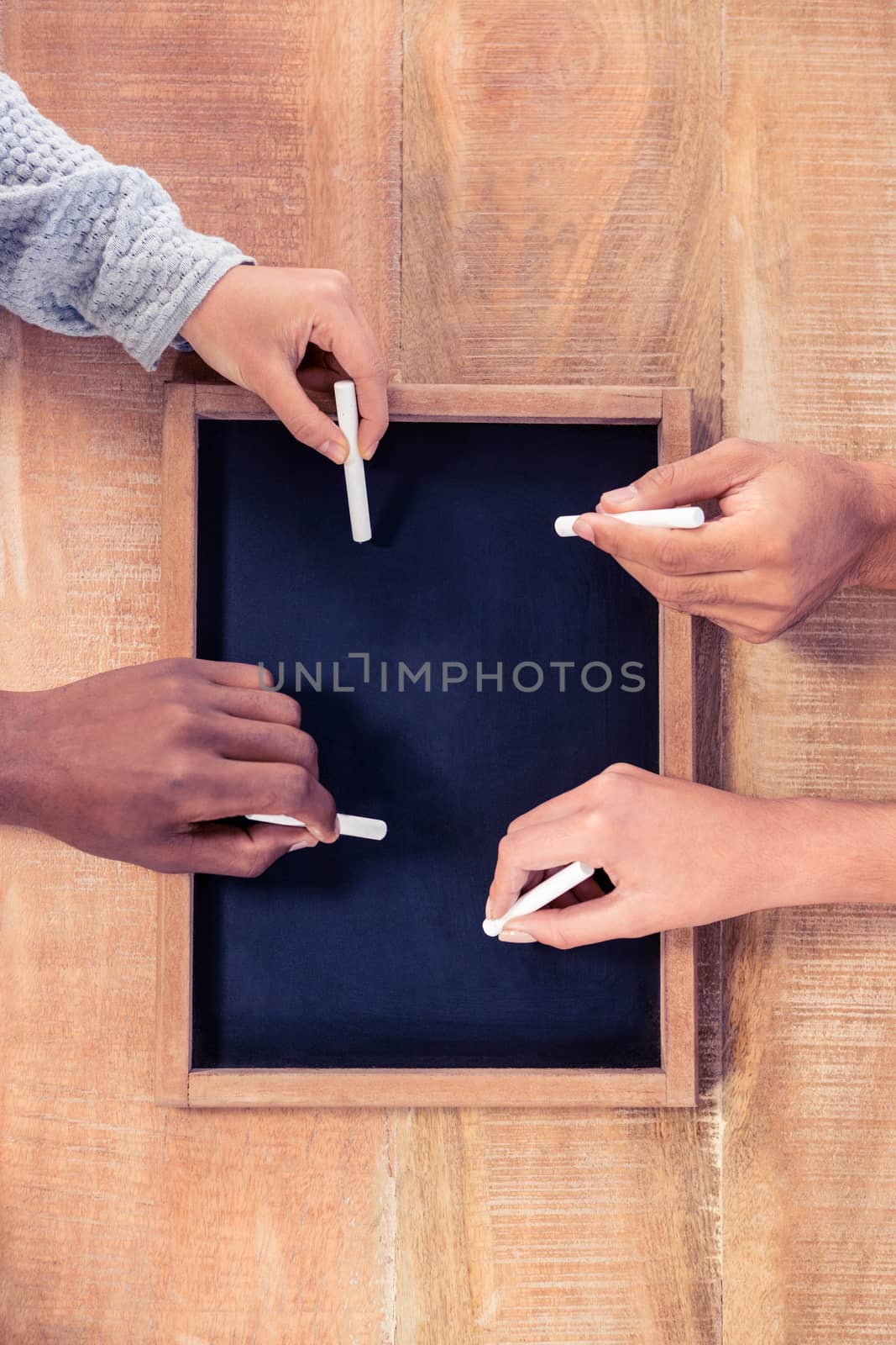 Cropped hands of business people writing on slate  by Wavebreakmedia