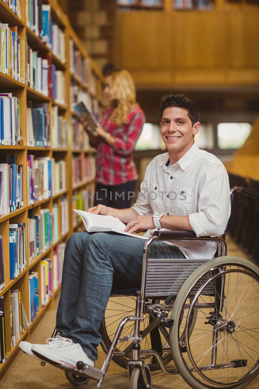 Student in wheelchair talking with classmate in library