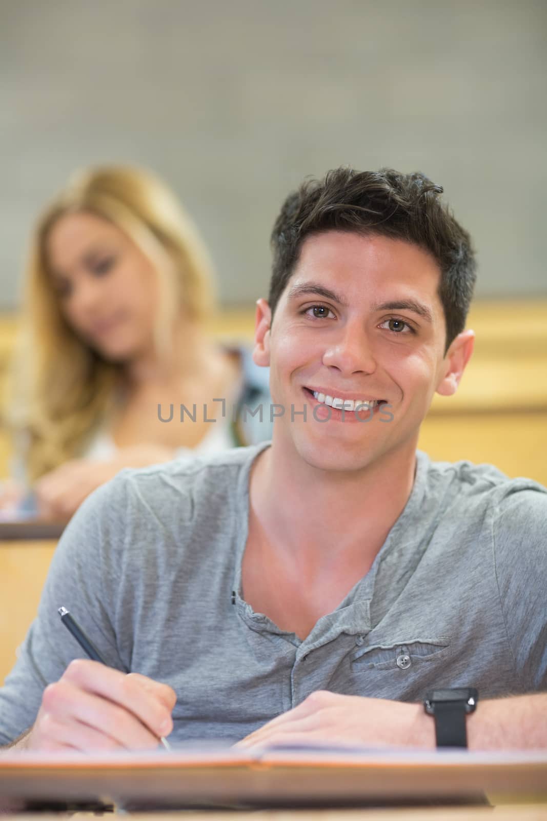 Smiling male student during class at the lecture hall