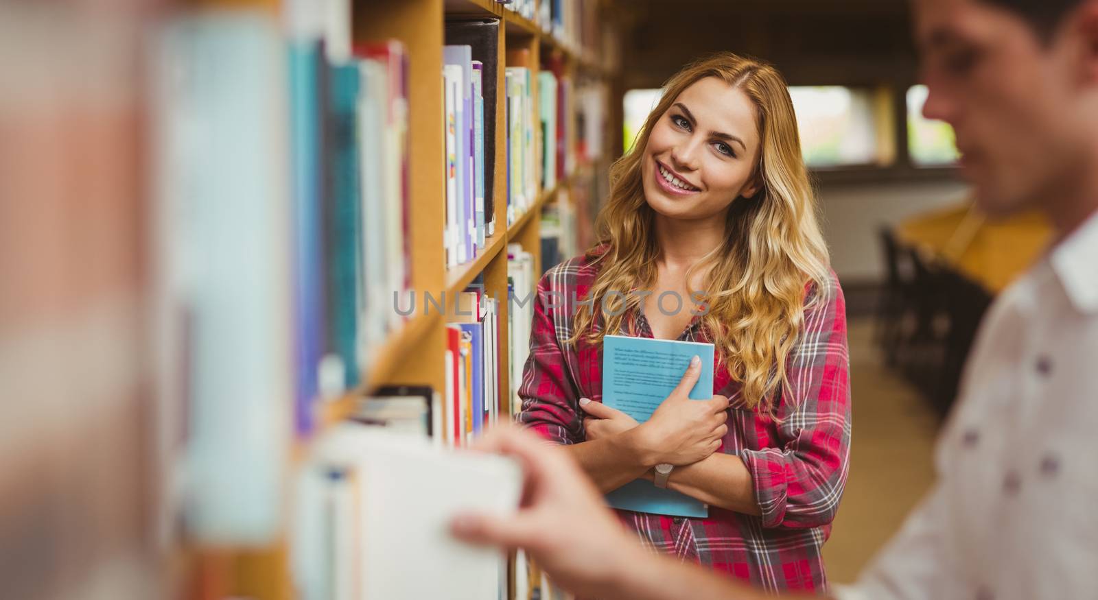 Smiling female student posing for camera in library