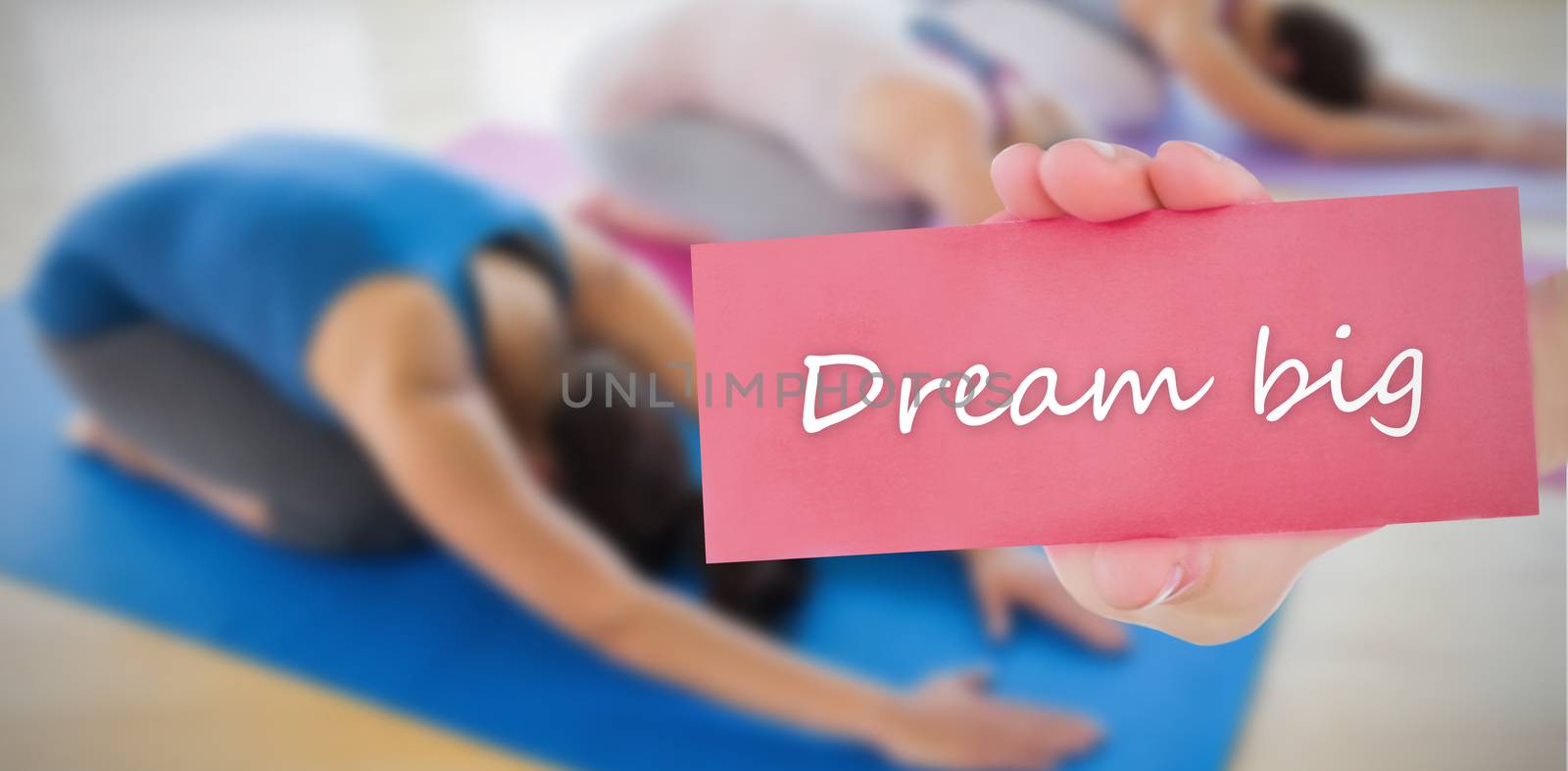 The word dream big and hand showing card against 