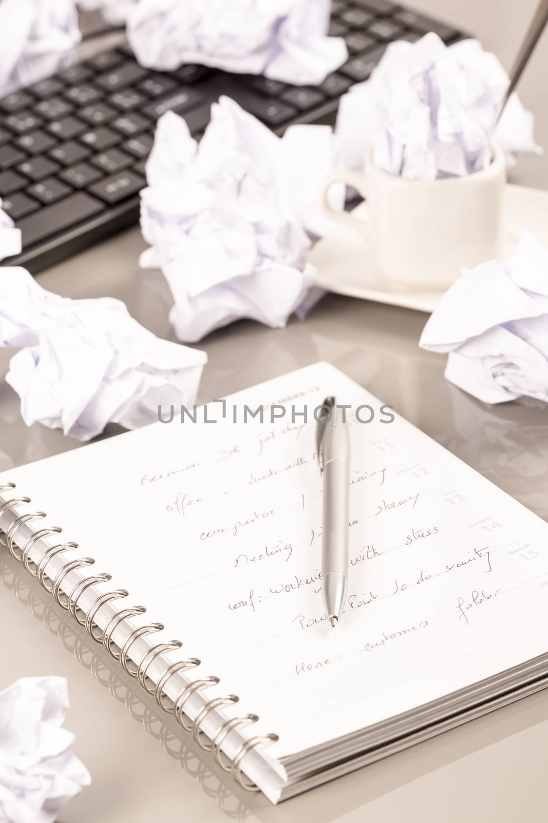 Office workplace with book, crumpled paper, pen,  on grey desk