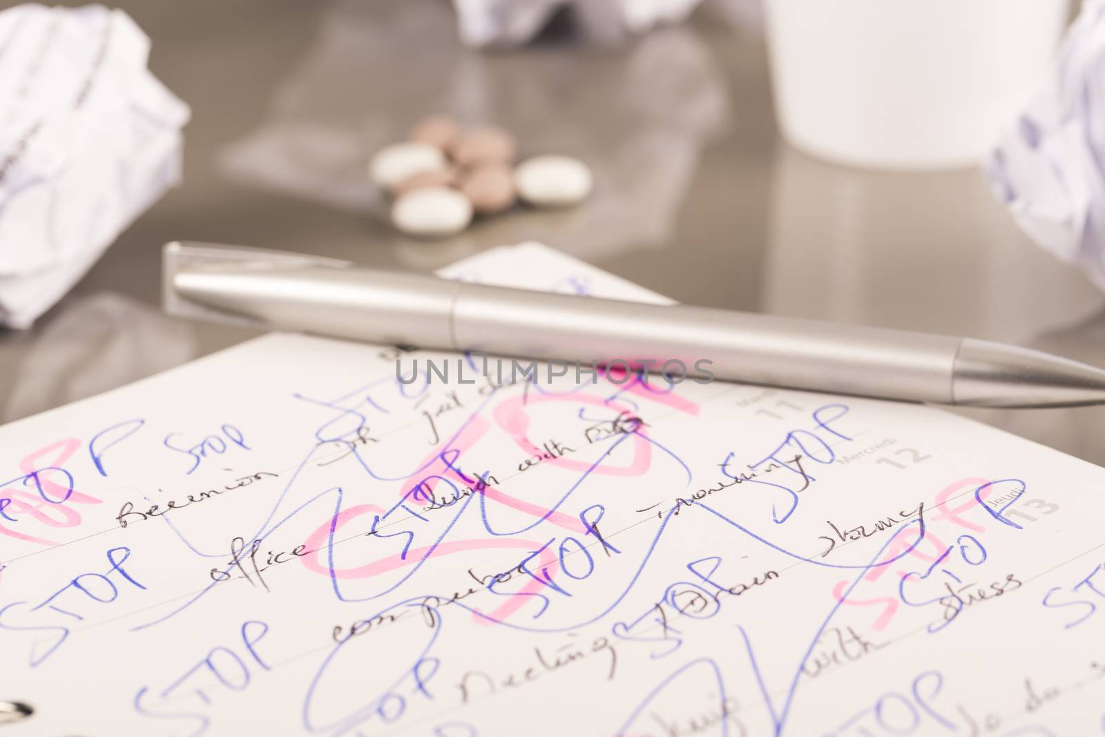 Office workplace with book, crumpled paper, pen,  on grey desk