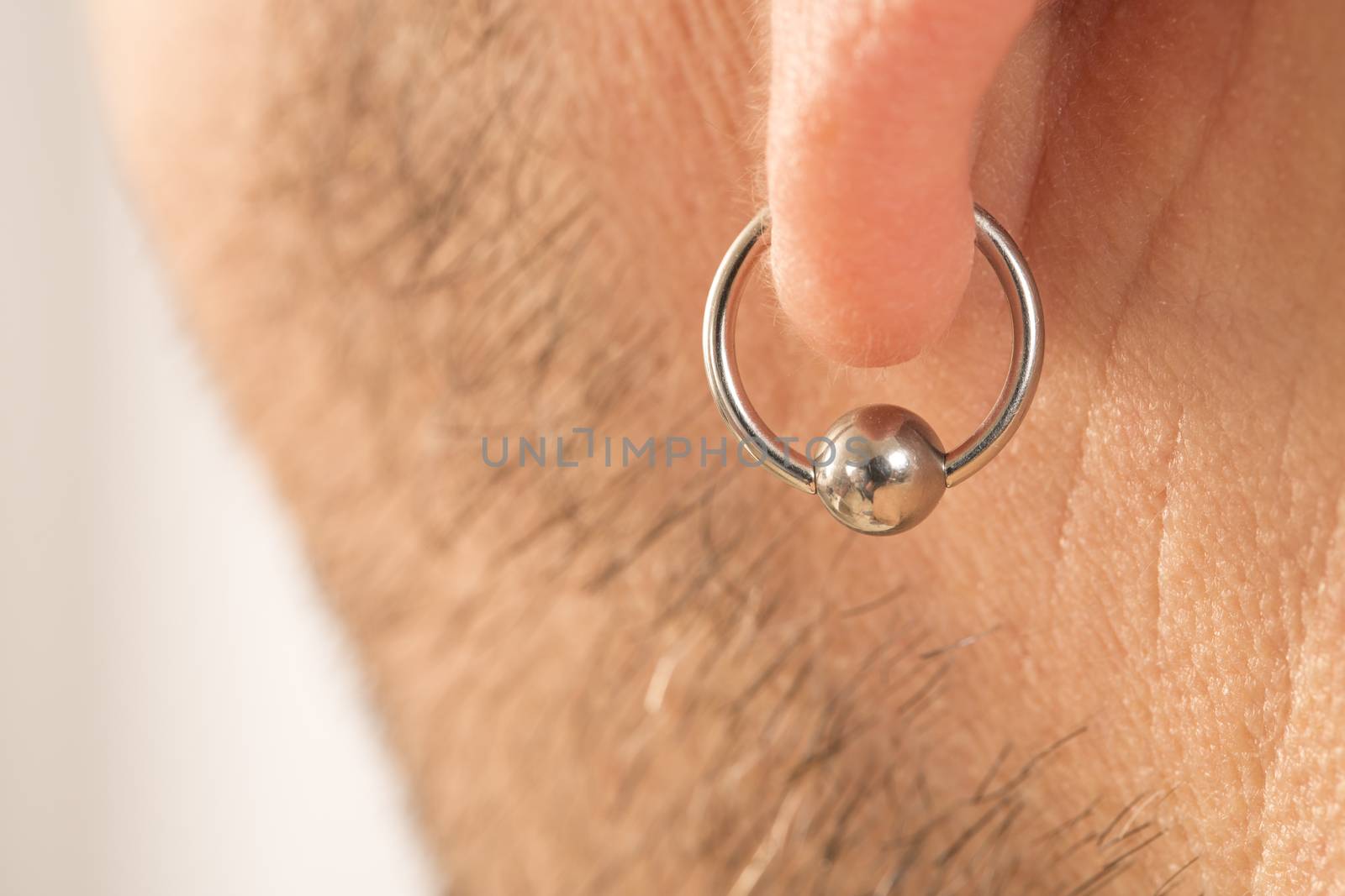 pierced ear of a  man by CatherineL-Prod
