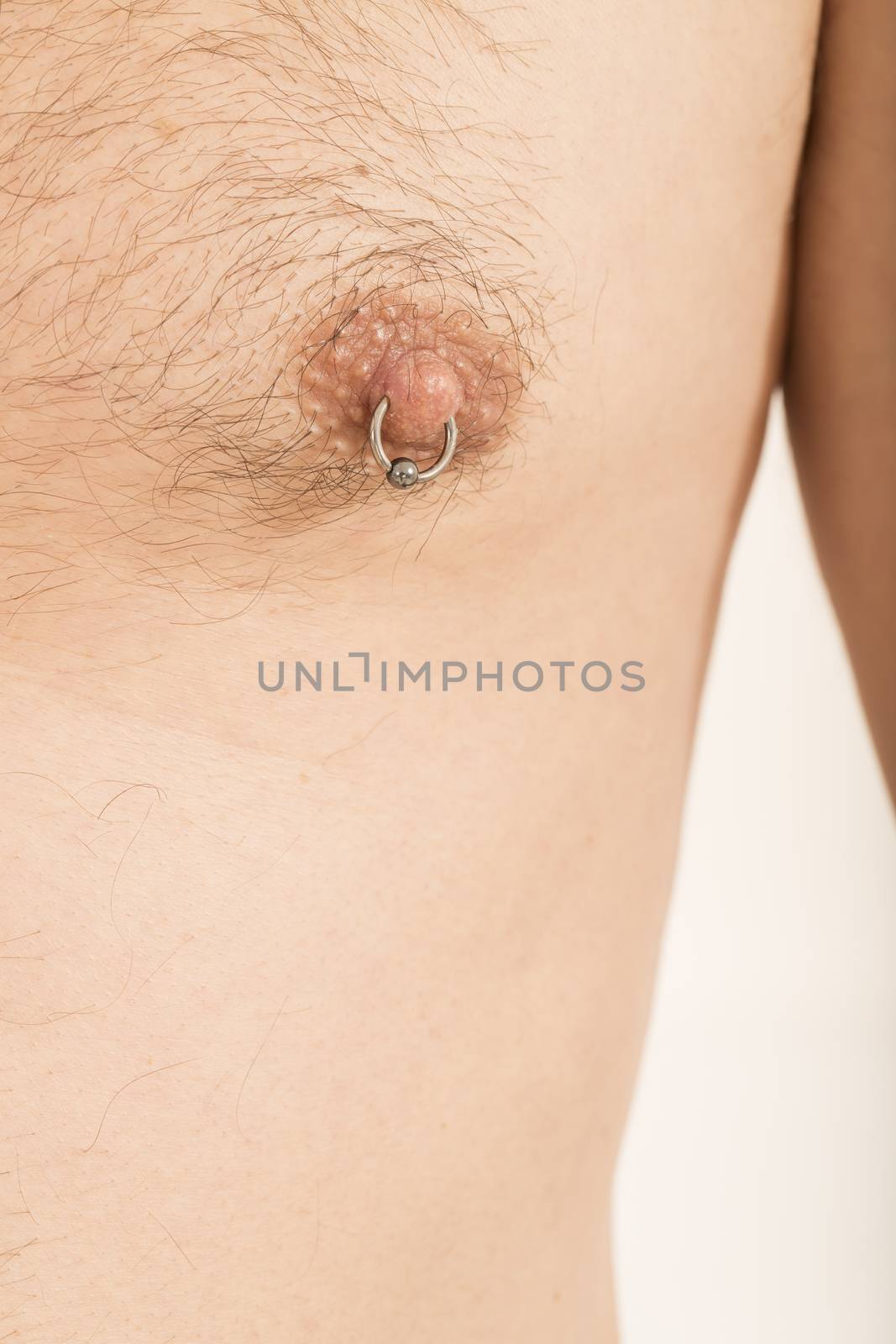Close up of muscular male torso with a nipple piercing