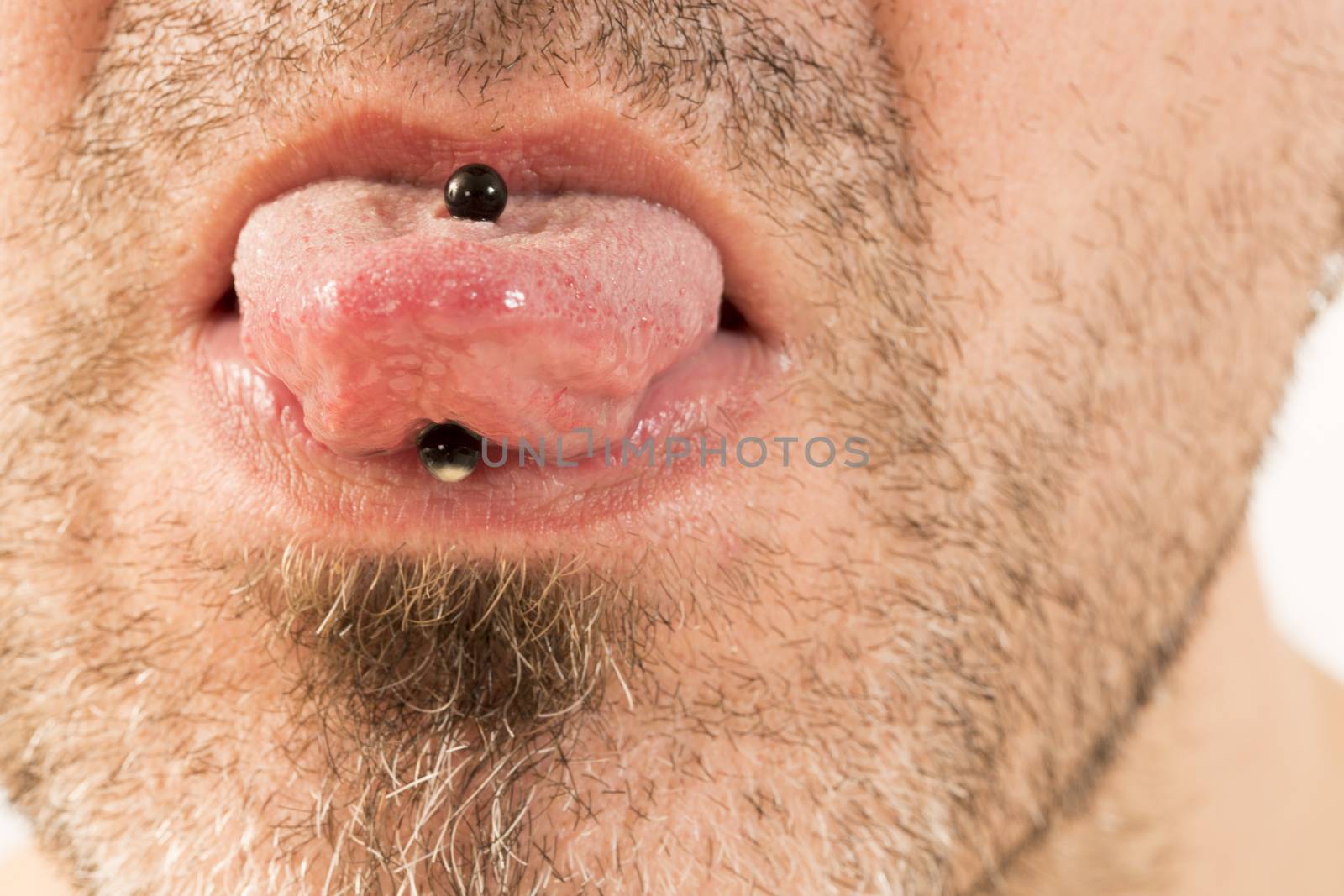 close-up of a mature man showing off his tongue ring