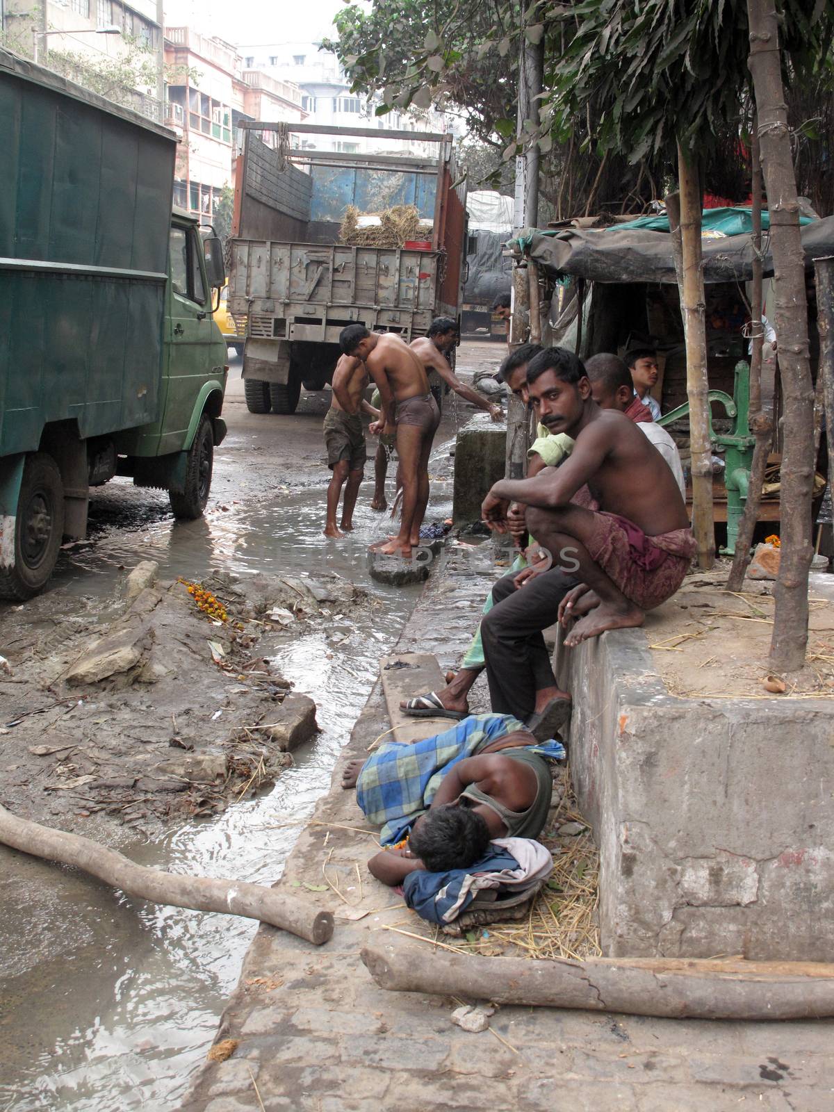 Streets of Kolkata. Indian people wash themselves on a street, January 25, 2009.