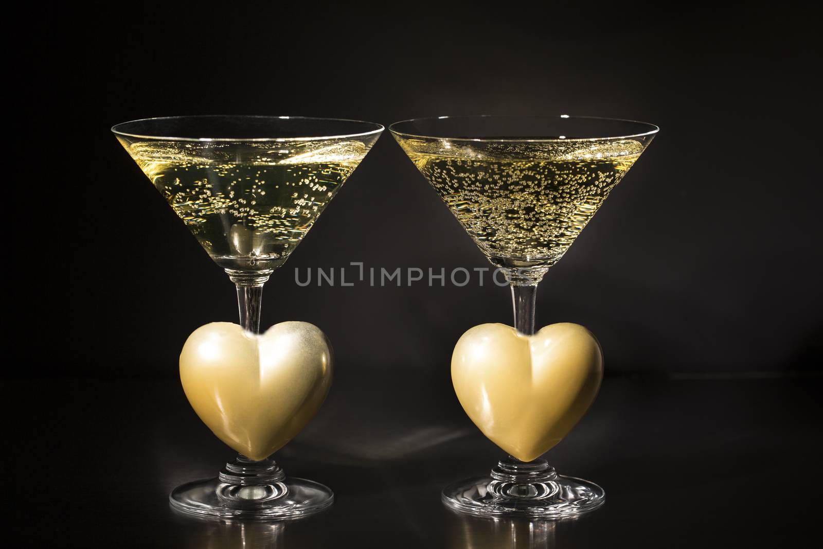 Champagne and valentines day decoration on black glitter background, love