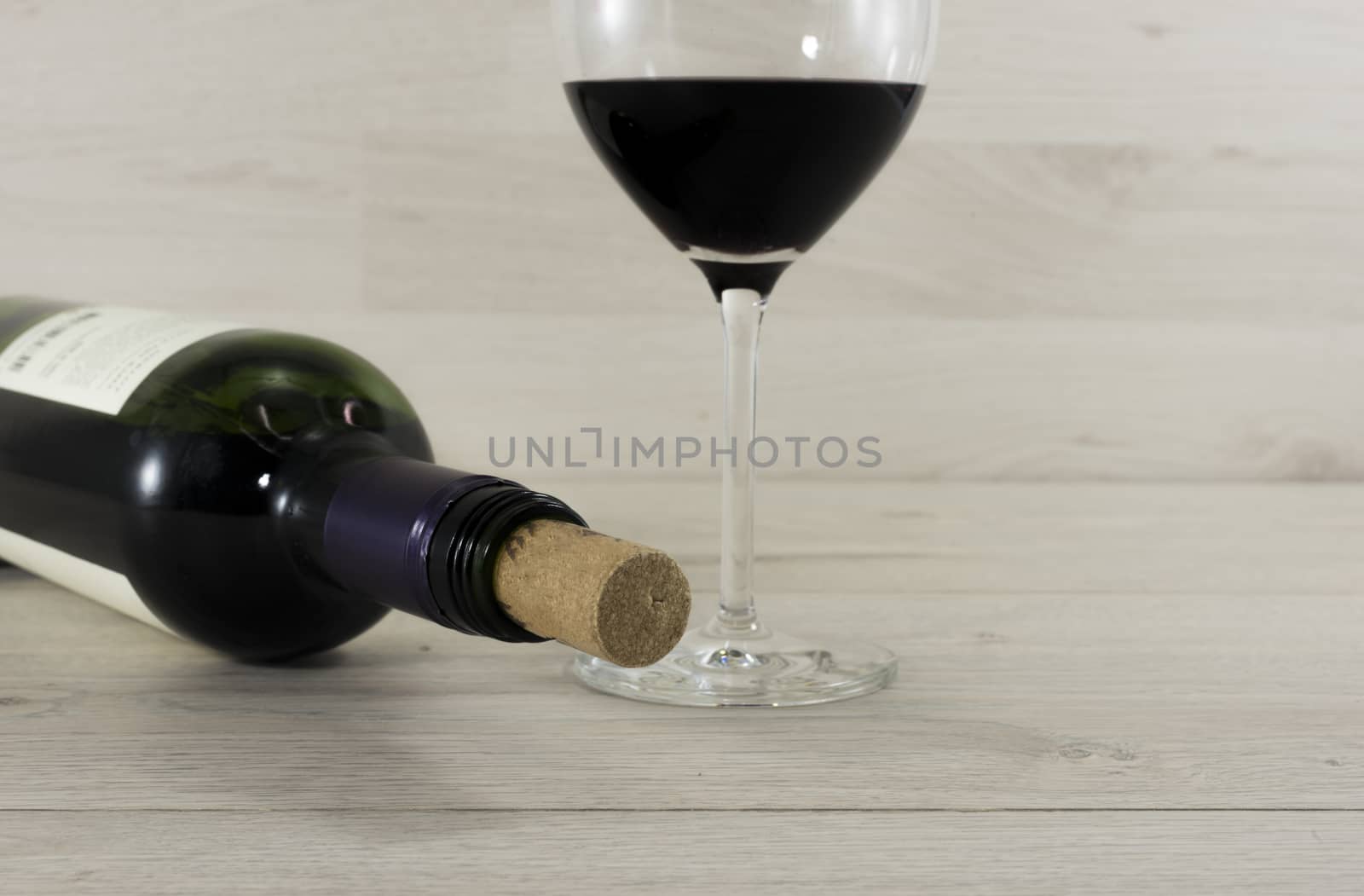 bottle red wine and glass on wooden background