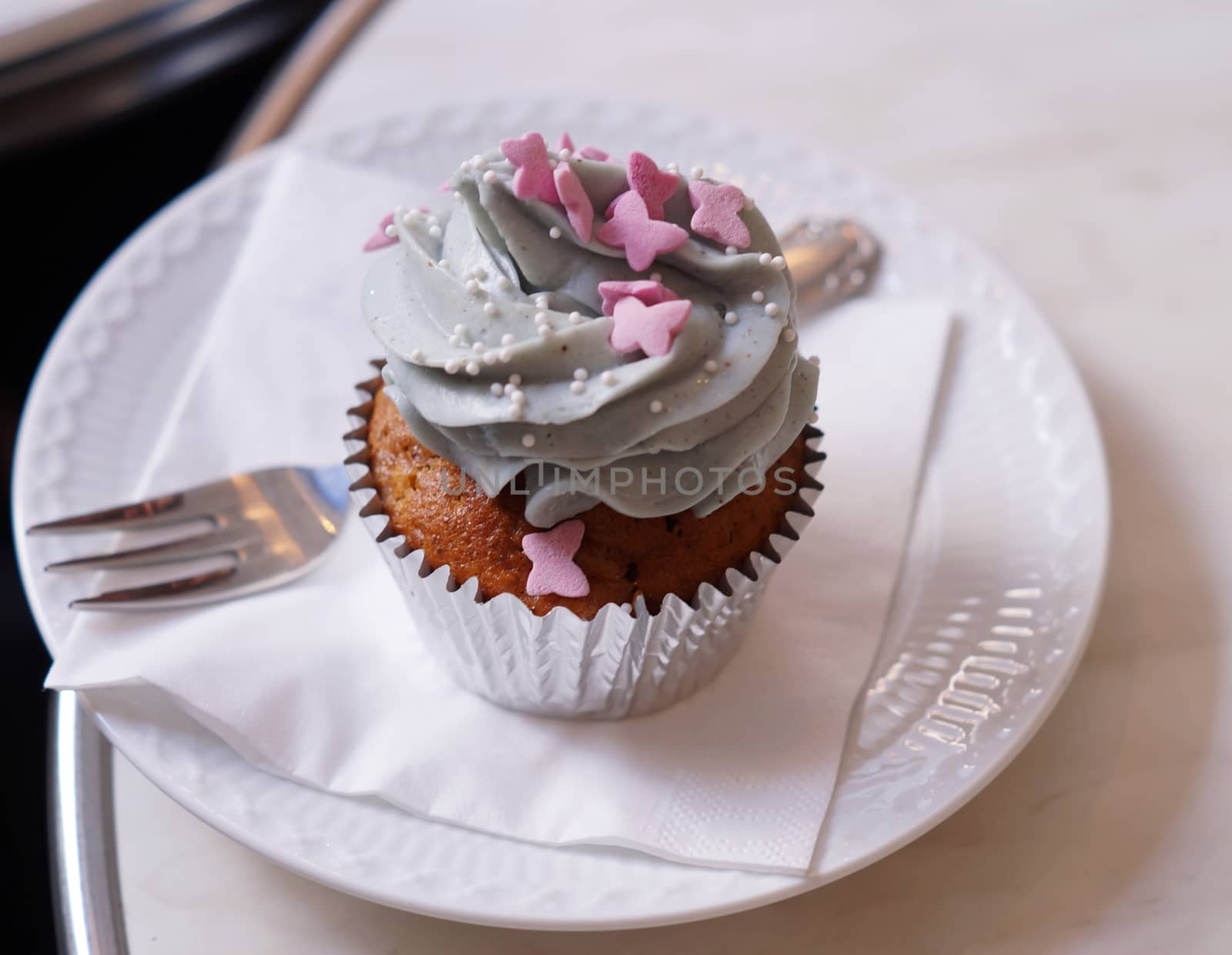 Cup cake on plate with fork napkin by celaler