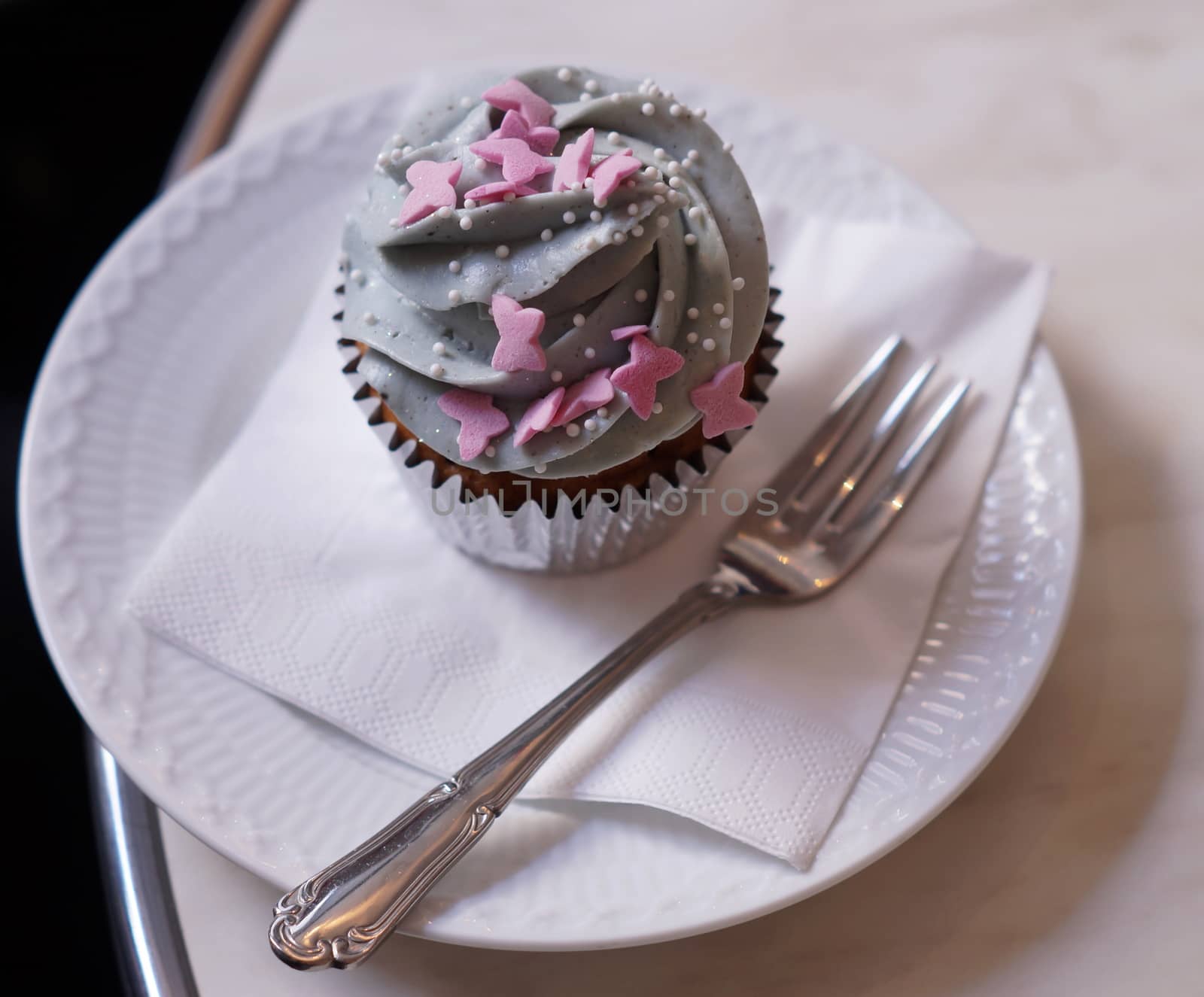 Cup cake on plate with fork napkin