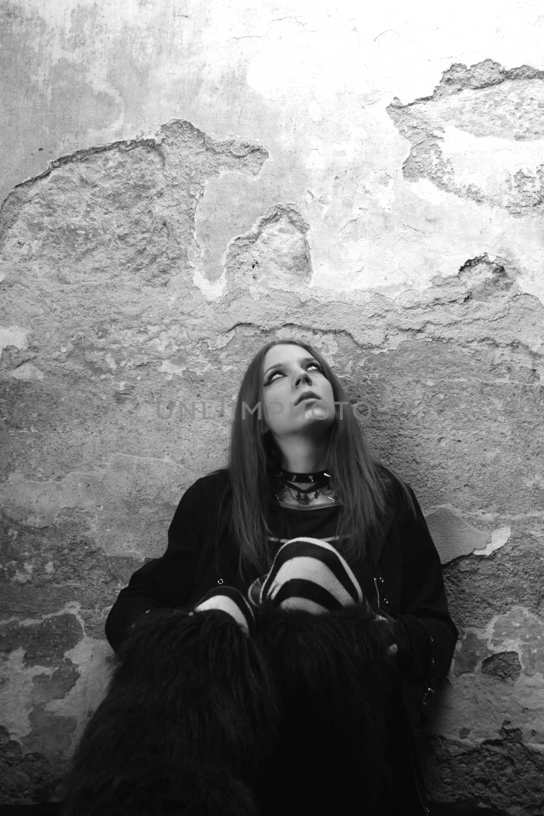 Beautiful serious girl by the wall