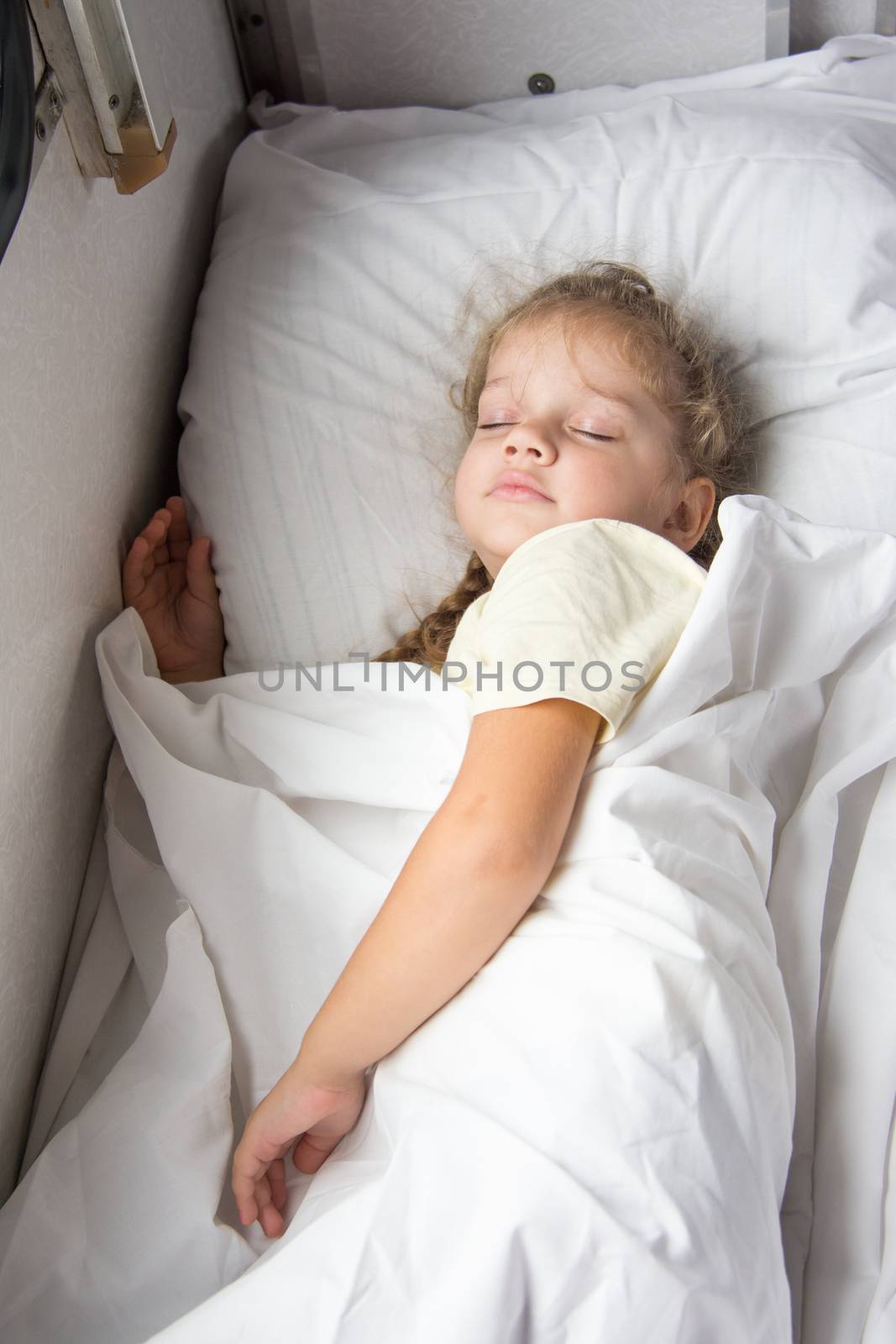 Four-year girl sleeping on the bottom shelf in a train by Madhourse