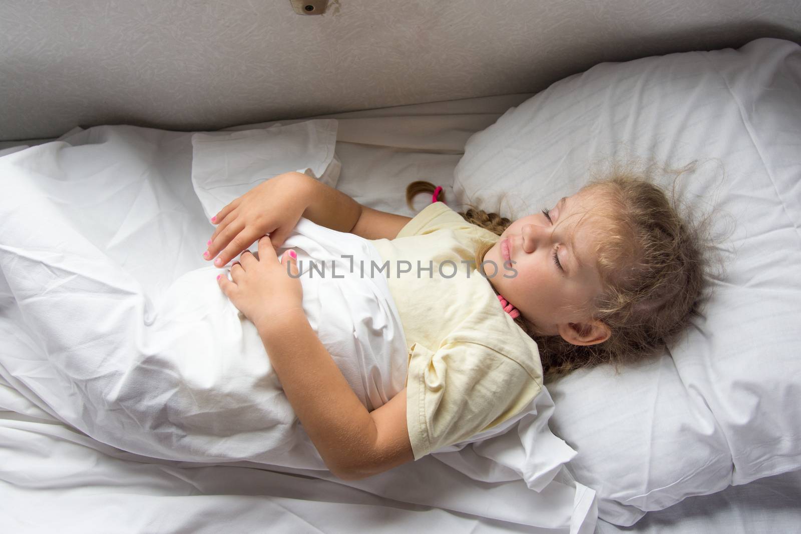 Four-year girl sleeping on a cot in a second-class train carriage