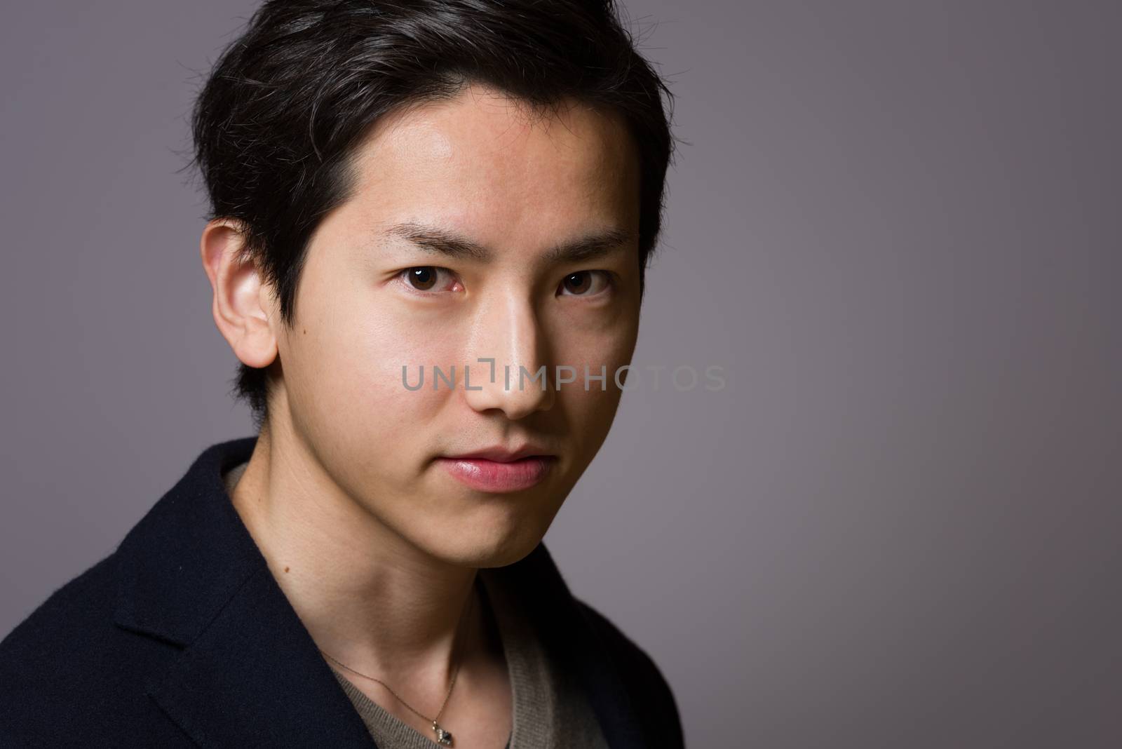 A headshot of a young handsome Japanese man.