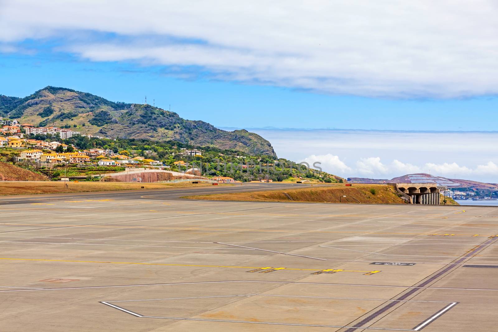 Santa Cruz, Madeira - June 9, 2013: Airport Madeira (Aeroporto da Madeira) - runway view from panorama terrace. Surrounding mountain landscape with typical houses.