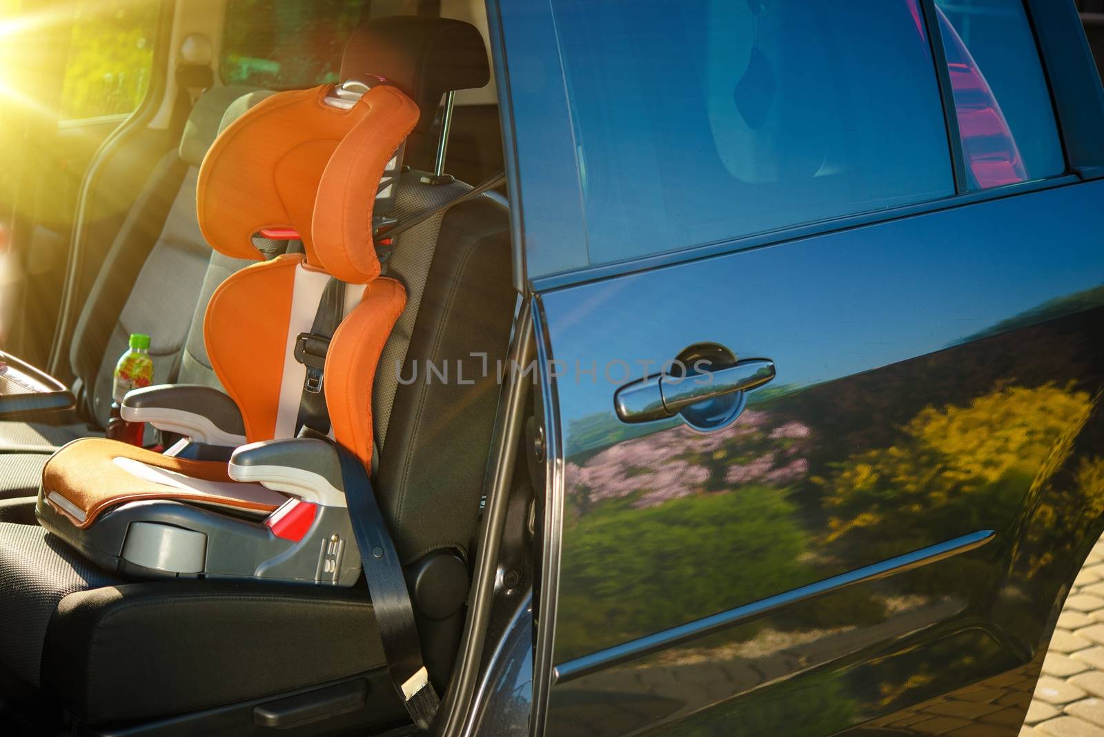 Child Car Safety Seat. Orange Car Seat Inside Small Family Van.