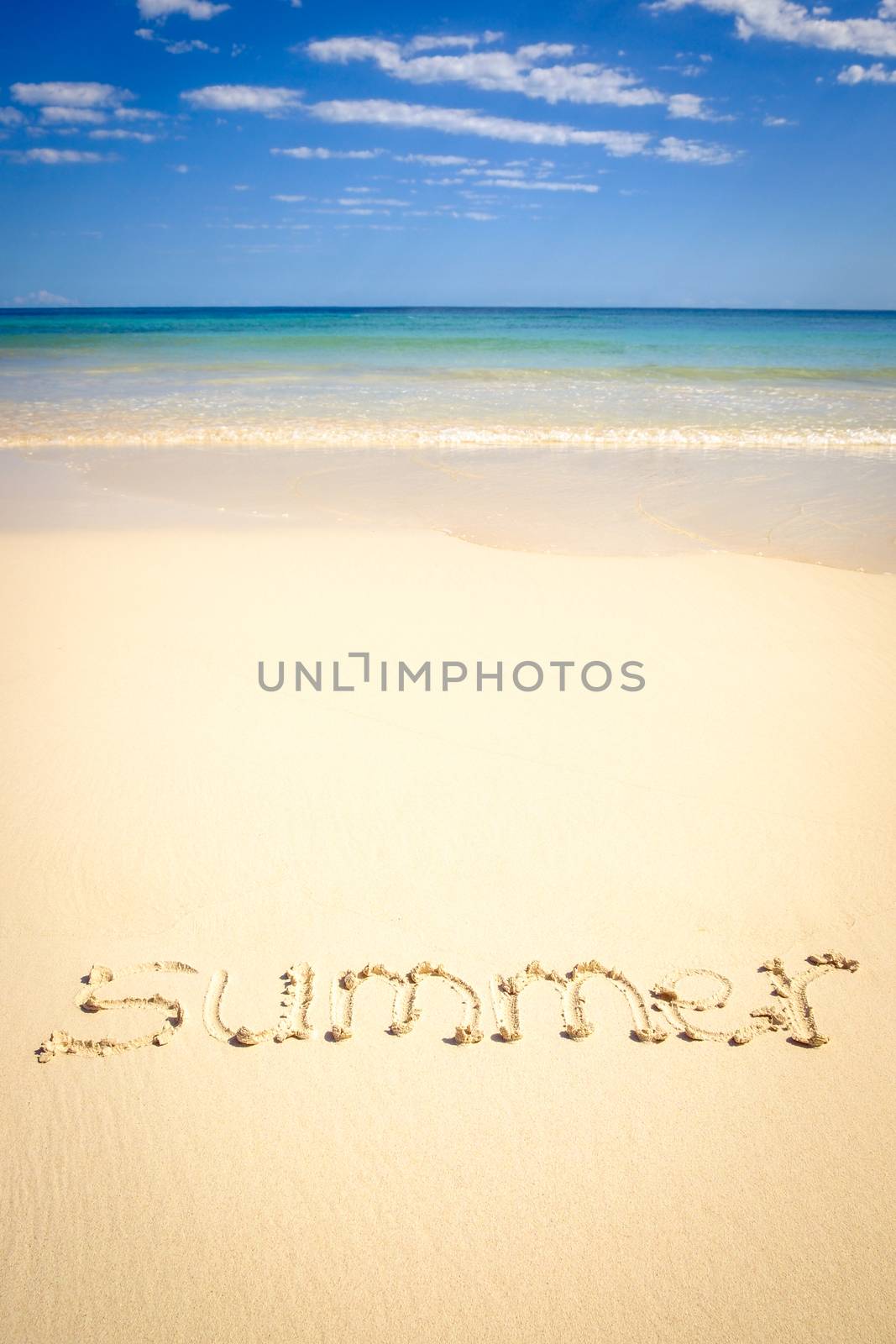 Conceptual image with summer sign in a beach sand with ocean background