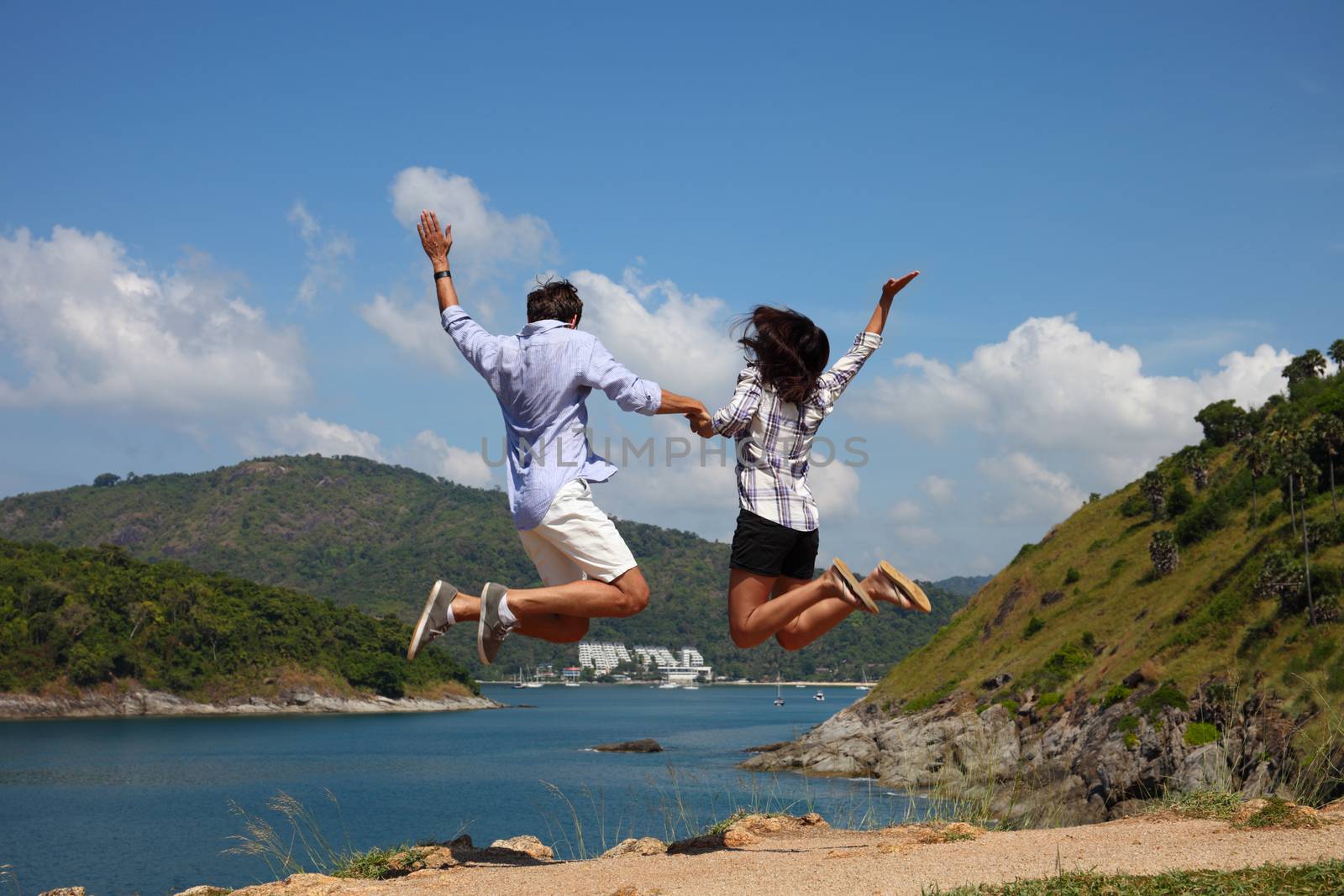 Young happy couple jump and enjoy beautiful sea view on vacation