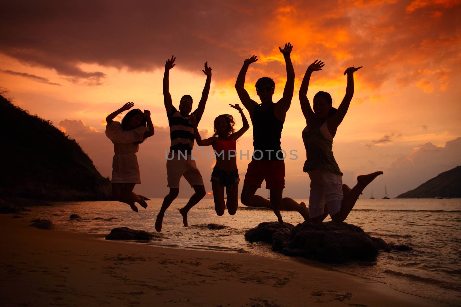 Group of people partying on beach at sunset