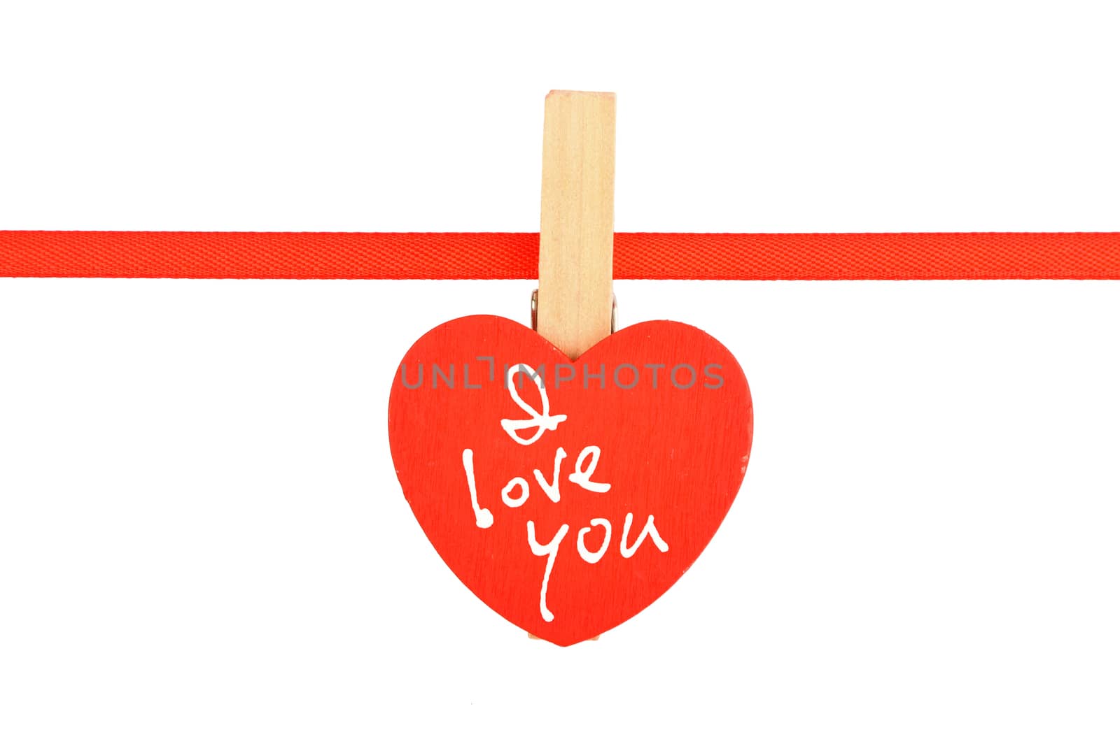 Red painted wooden heart with clothes pin on textile ribbon with I love you text message isolated on white background