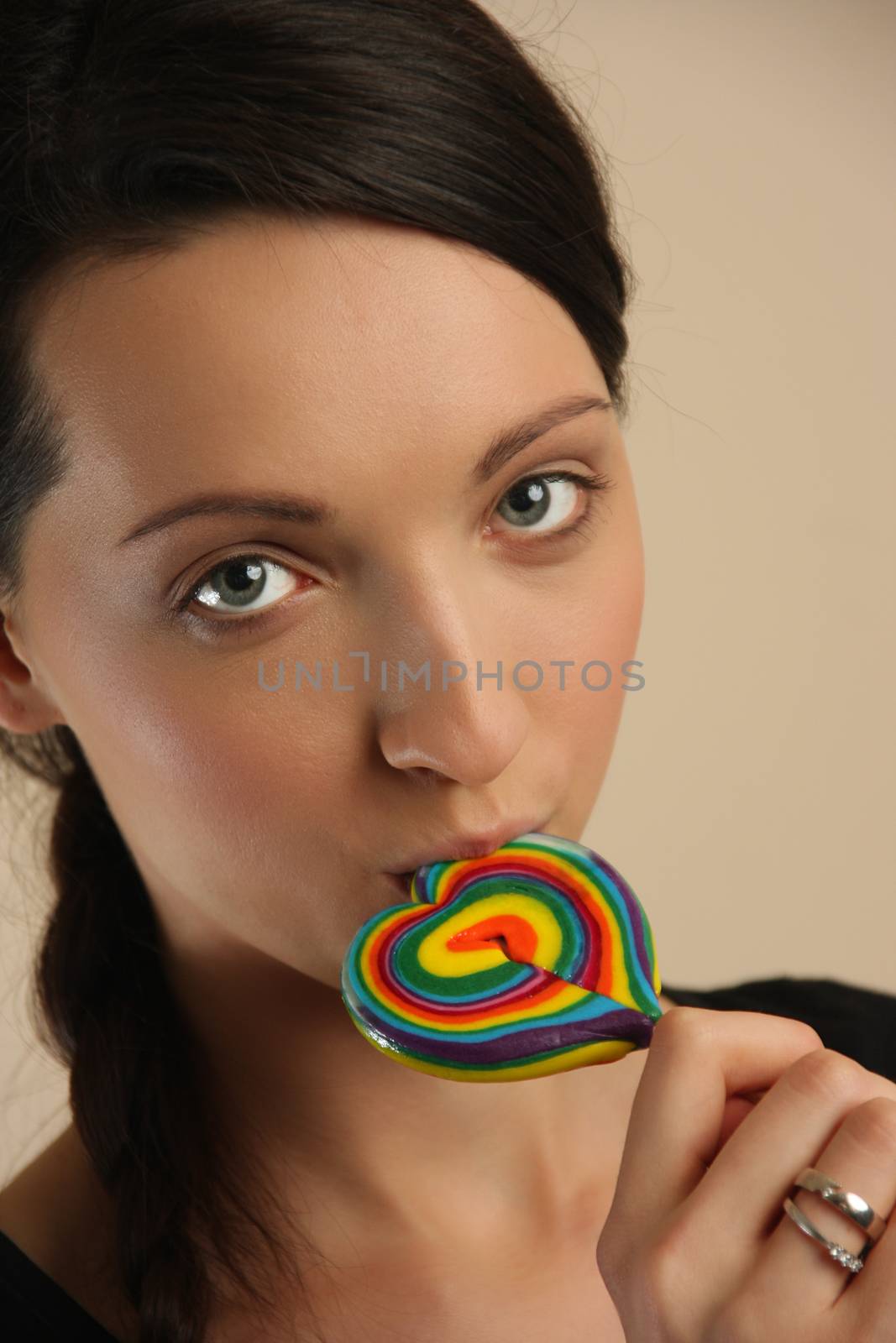 Girl licking a coloful lollipop.