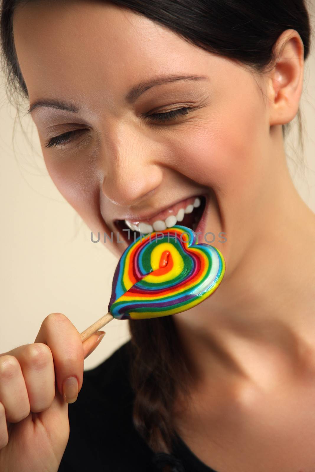 Girl licking a coloful lollipop.