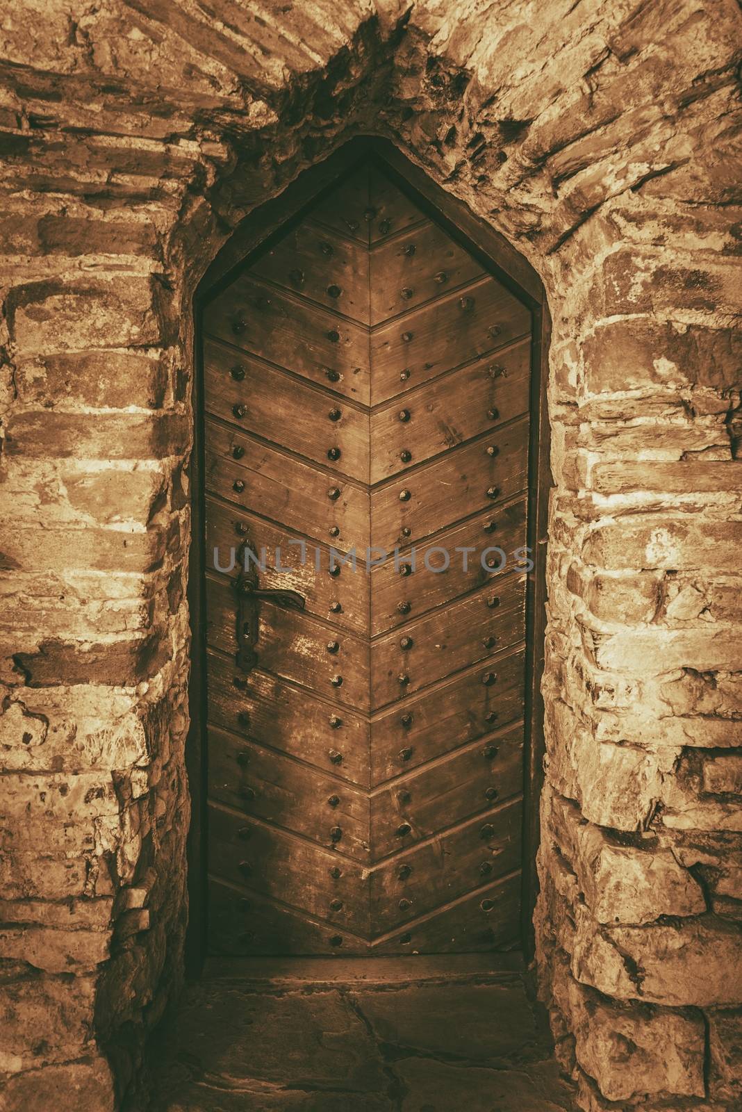Vintage Wooden Castle Doors. Aged Stone Walls and the Medieval Wooden Door.