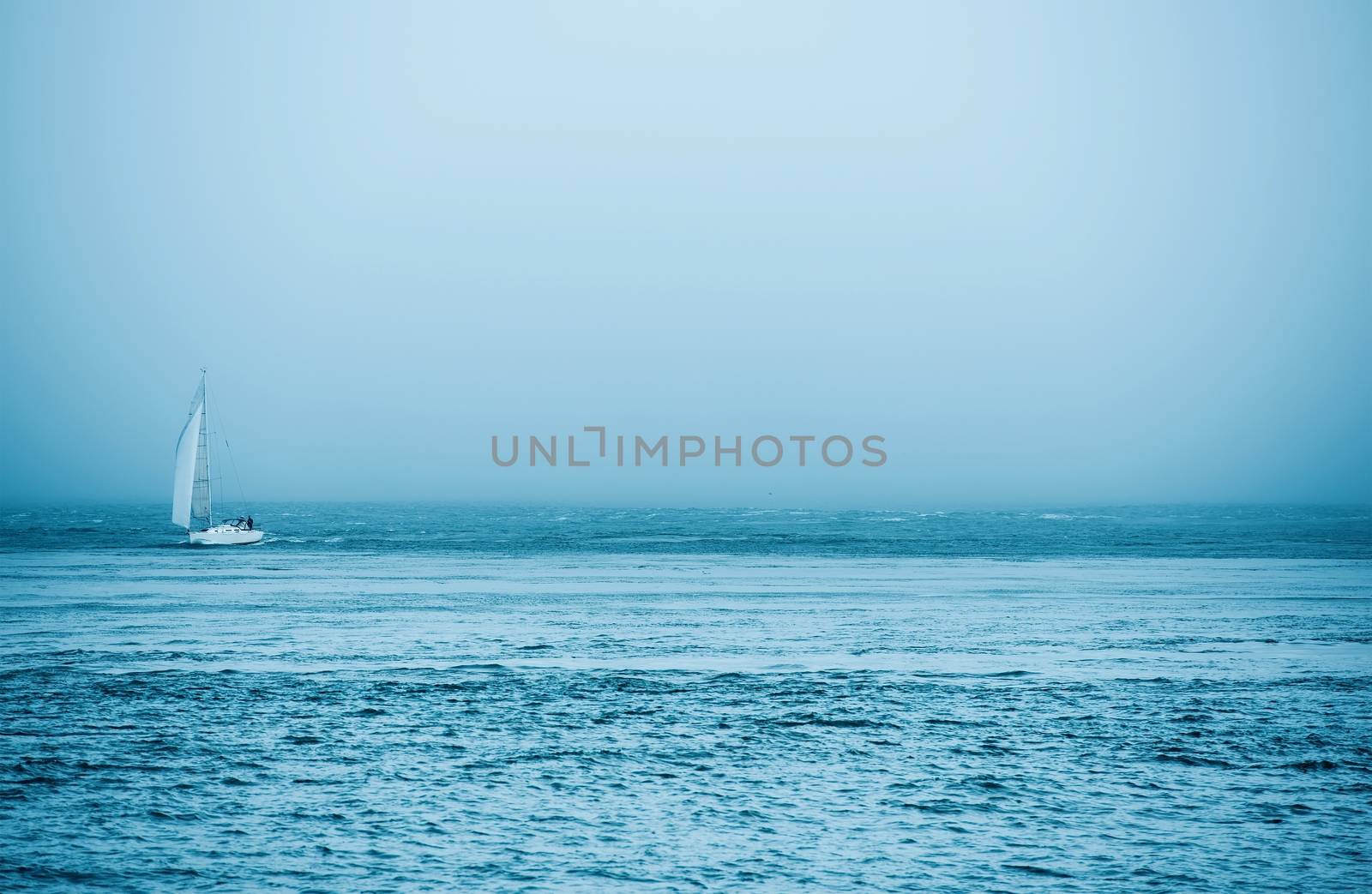 Yacht and the Sea. Small Boat on the Ocean with Foggy Weather.