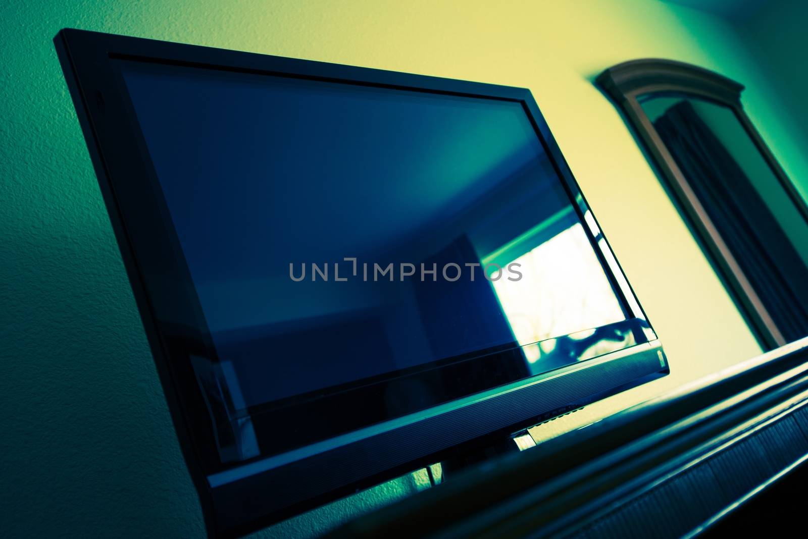 Flat Screen TV in a Room. Television Device. Dark Greenish Blue Color Grading.