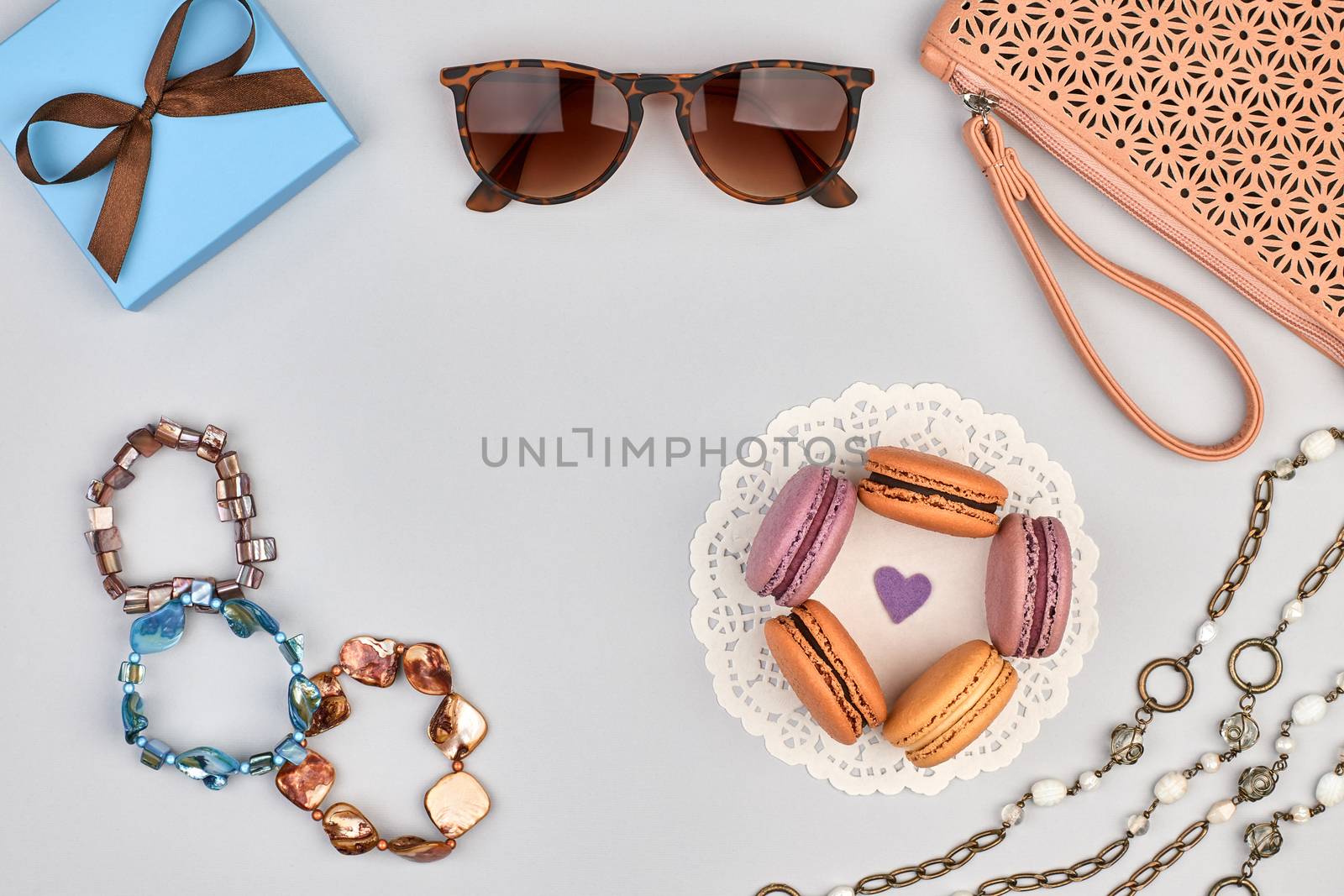 Overhead outfit Fashion clothes set, macarons french dessert, accessories. Glamor creative, handbag clutch sunglasses gift box, necklace, bracelet. Unusual modern party essentials.Top view,background
