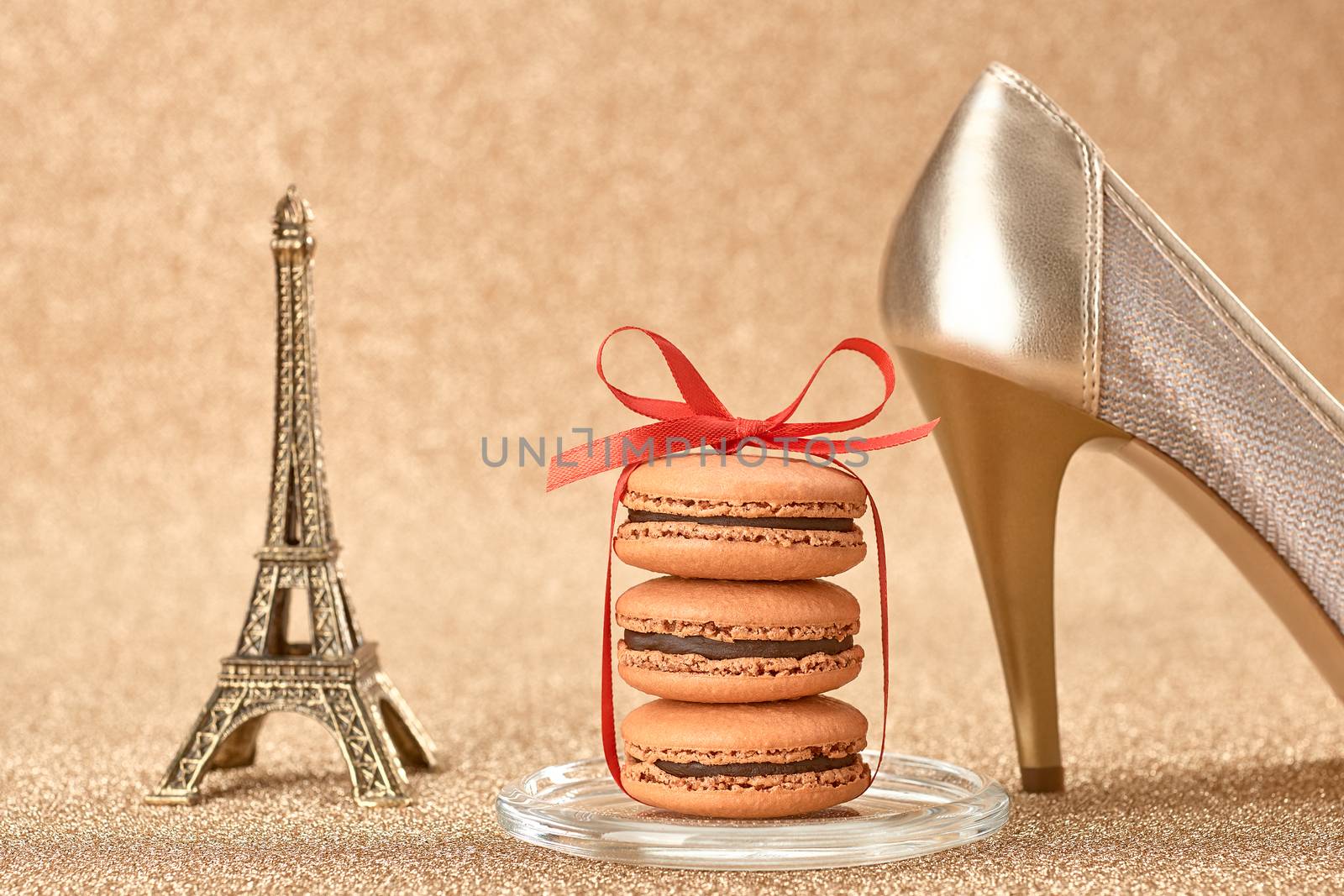 Macarons french dessert, Luxury shiny shoes high heels, Eiffel Tower, souvenir from Paris, red ribbon. Vintage retro romantic style. Unusual creative art greeting card, gold background, bokeh