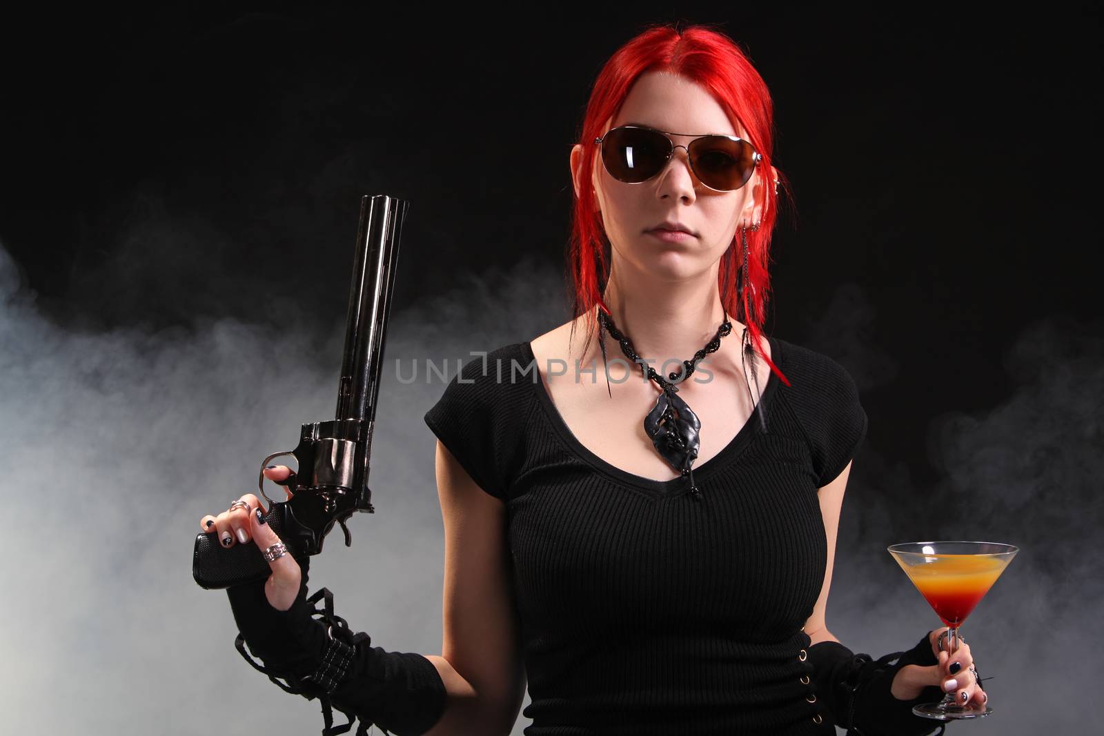 Sexy red hair woman with a gun and a cocktail