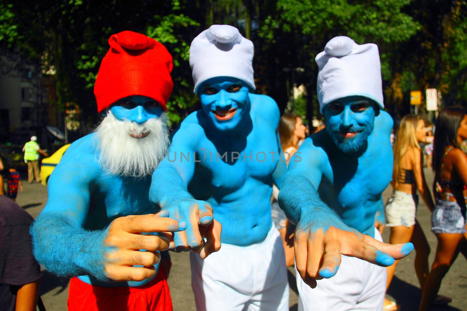 BRAZIL, Rio de Janeiro: Three men dress up as smurfs as  thousands of revelers take over the city on January 23, 2016 in a massive street party two weeks ahead of Carnival.  In the weeks leading up to the Carnival's official opening day on February 5, 2016, groups of people organize 'blocos', or street parties. Blocos are usually held in local neighbourhoods and feature brass bands and are much less formal than the parades.	 