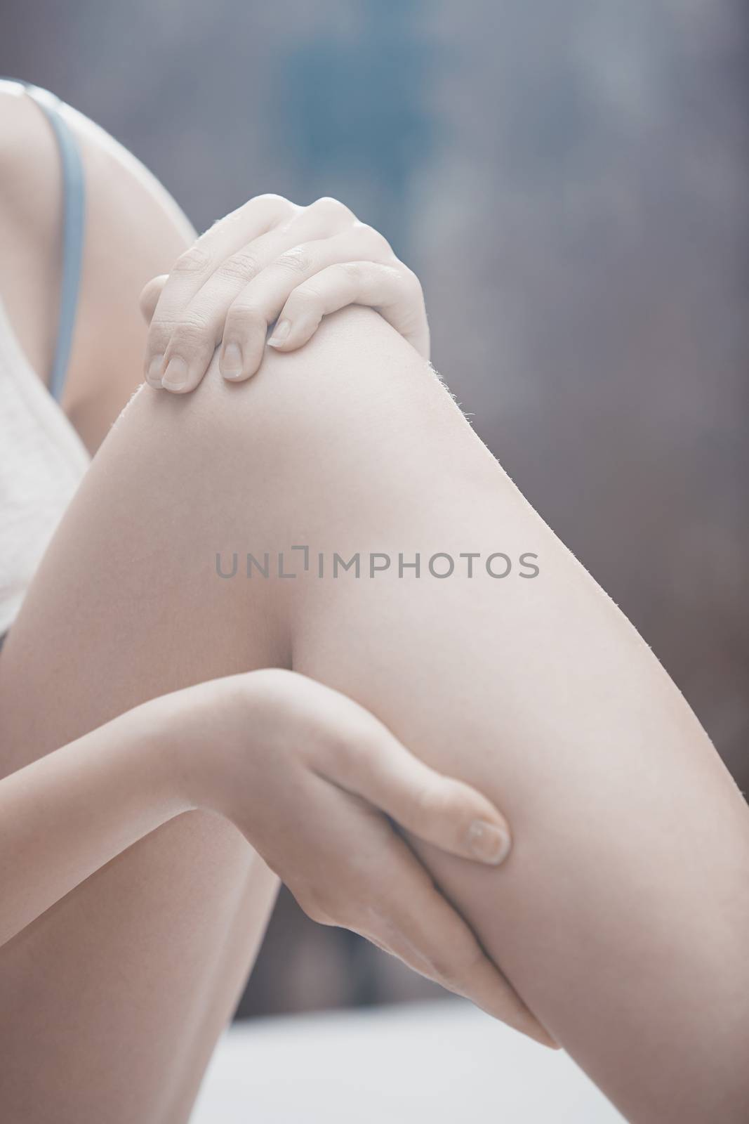 Woman doing leg massage and applying moisturizing cream