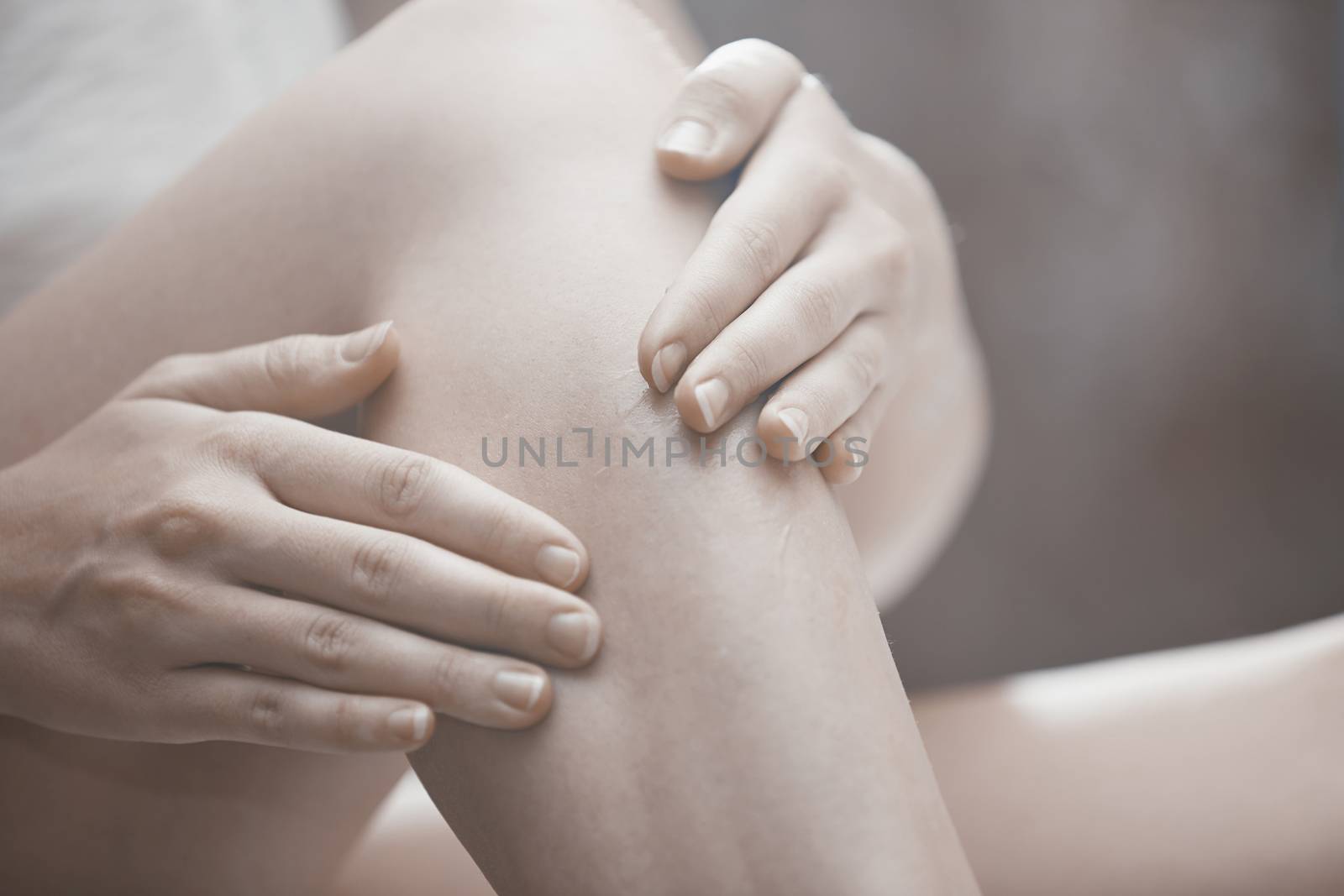 Woman doing leg massage and applying moisturizing cream