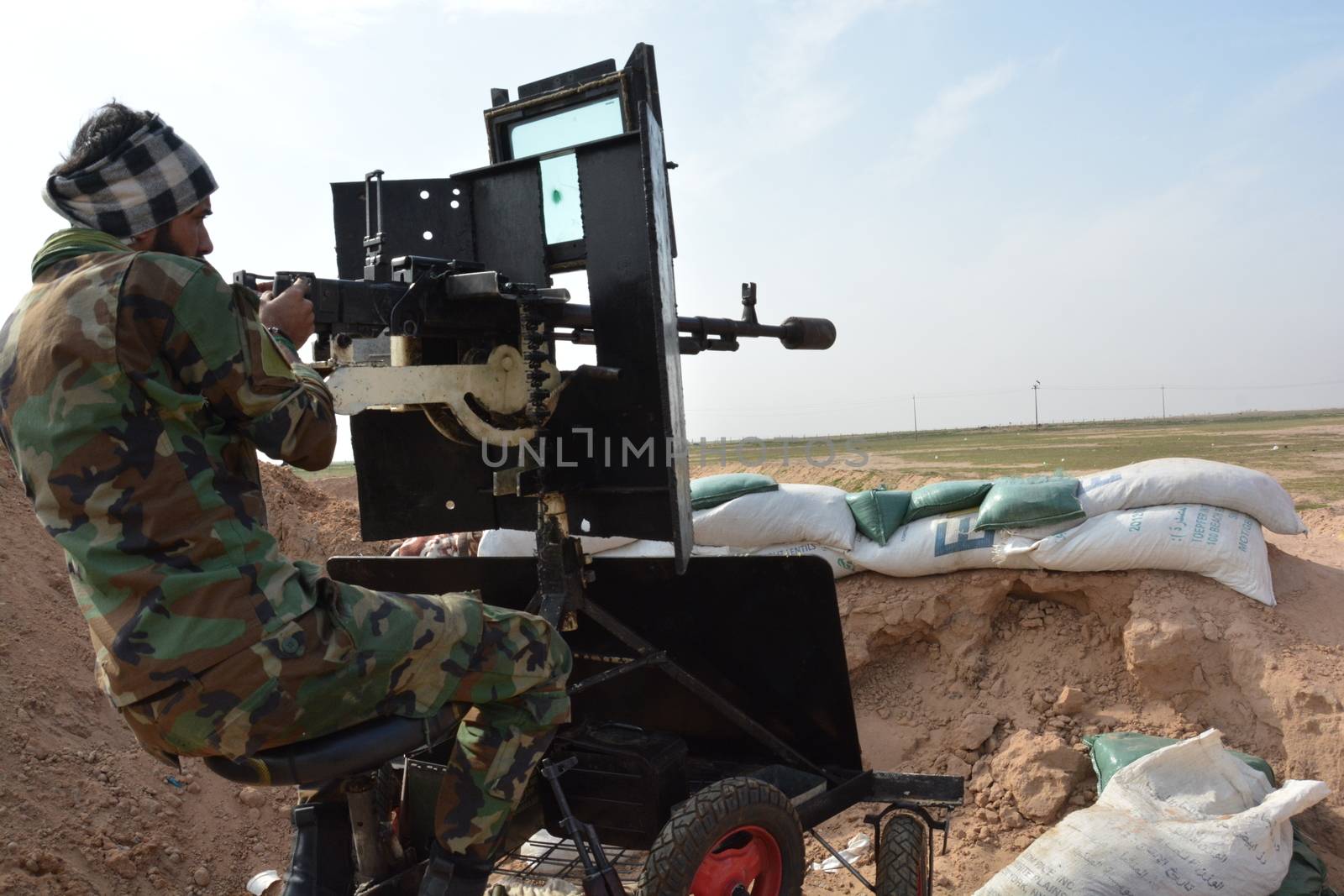 IRAQ, Al-Seneia: A PMU fighter looks through his gun sight on January 23, 2016, after the city of Al-Seneia was liberated from ISIS.The city was liberated on October 14, 2015, according to commander of Imam Ali brigade who spoke with our contributor. ISIS is said to have destroyed much of the town including important building such as schools and hospitals.