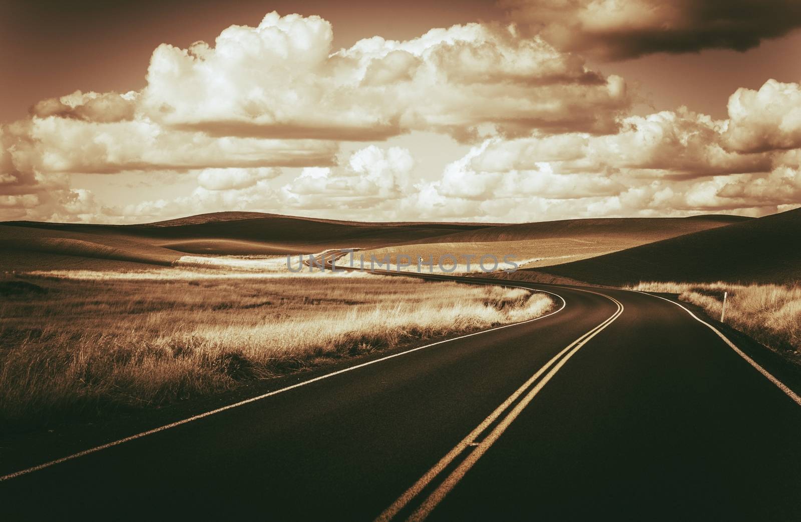 Scenic Winding Road and Butted Landscape in Dark Sepia Color Grading. Eastern Washington State, USA.
