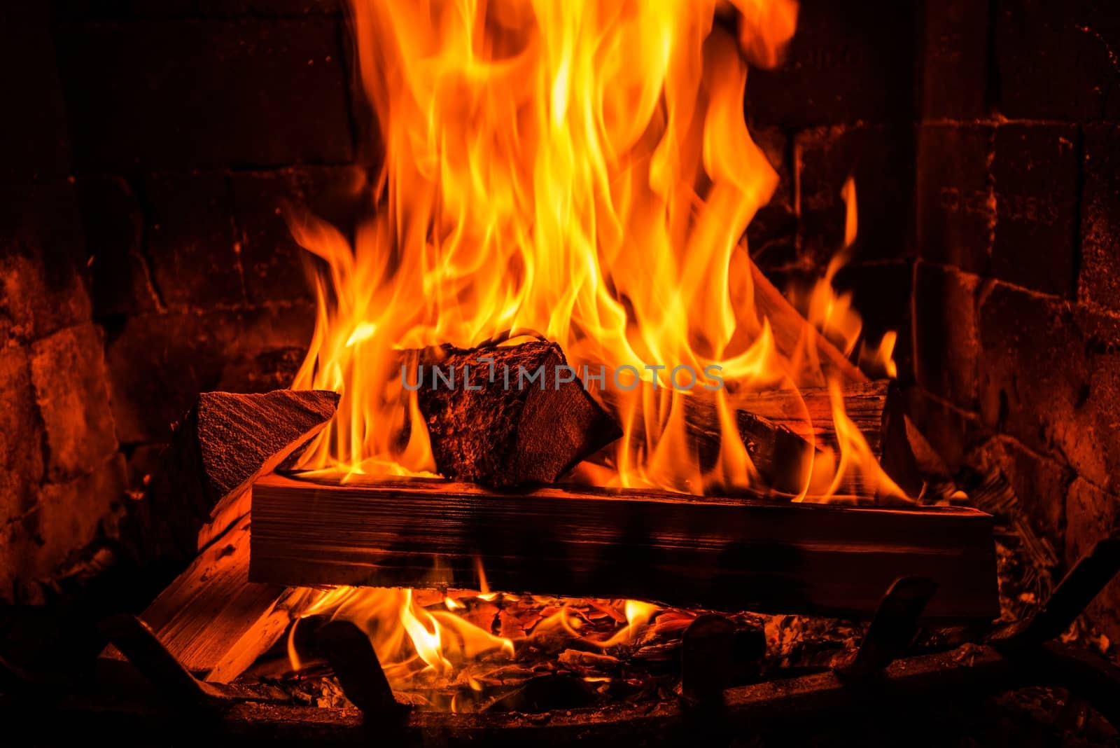 Burning Wood Logs in a Vintage Brick Fireplace. 