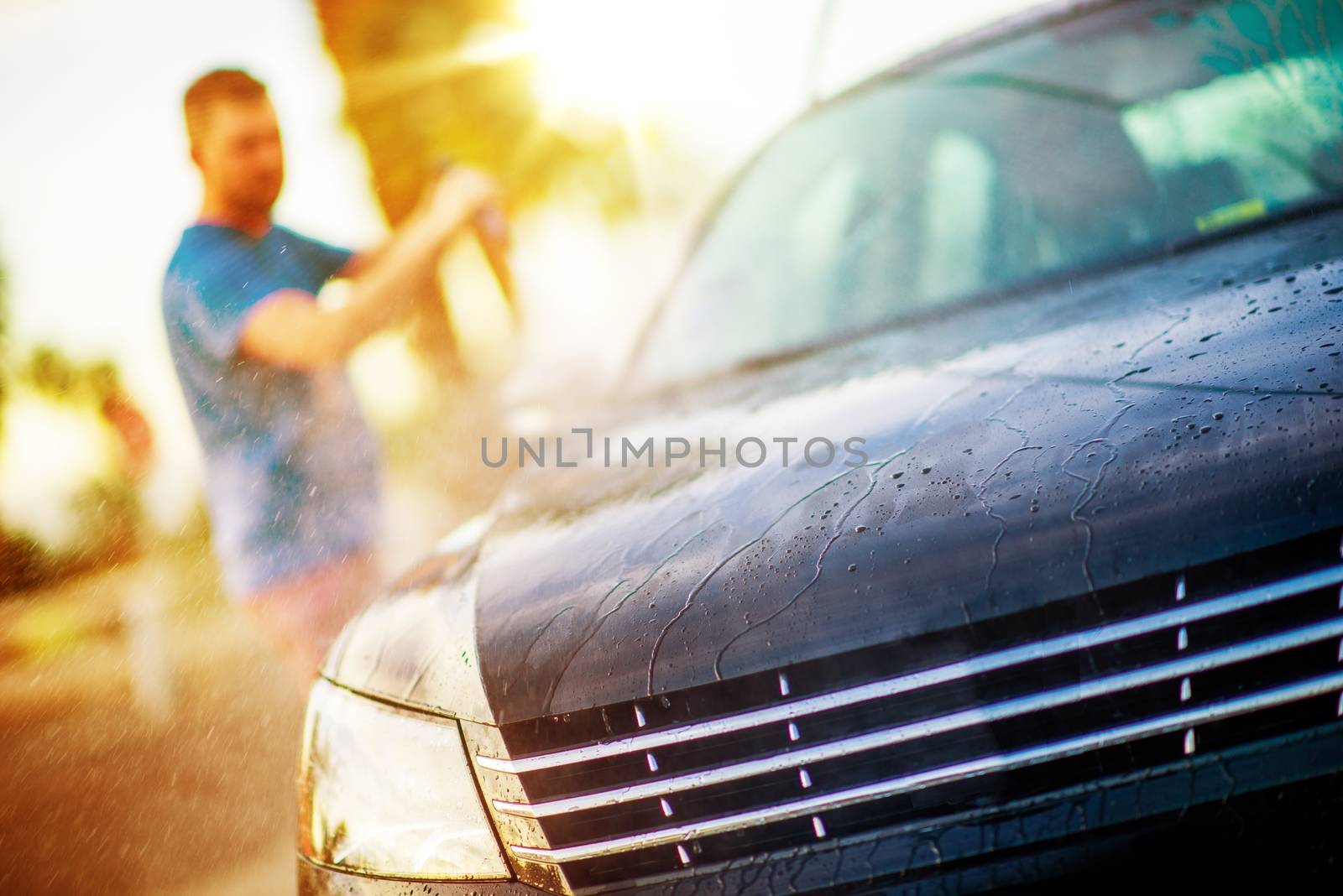 Men Washing His Car Using Self Service Car Wash Equipment.