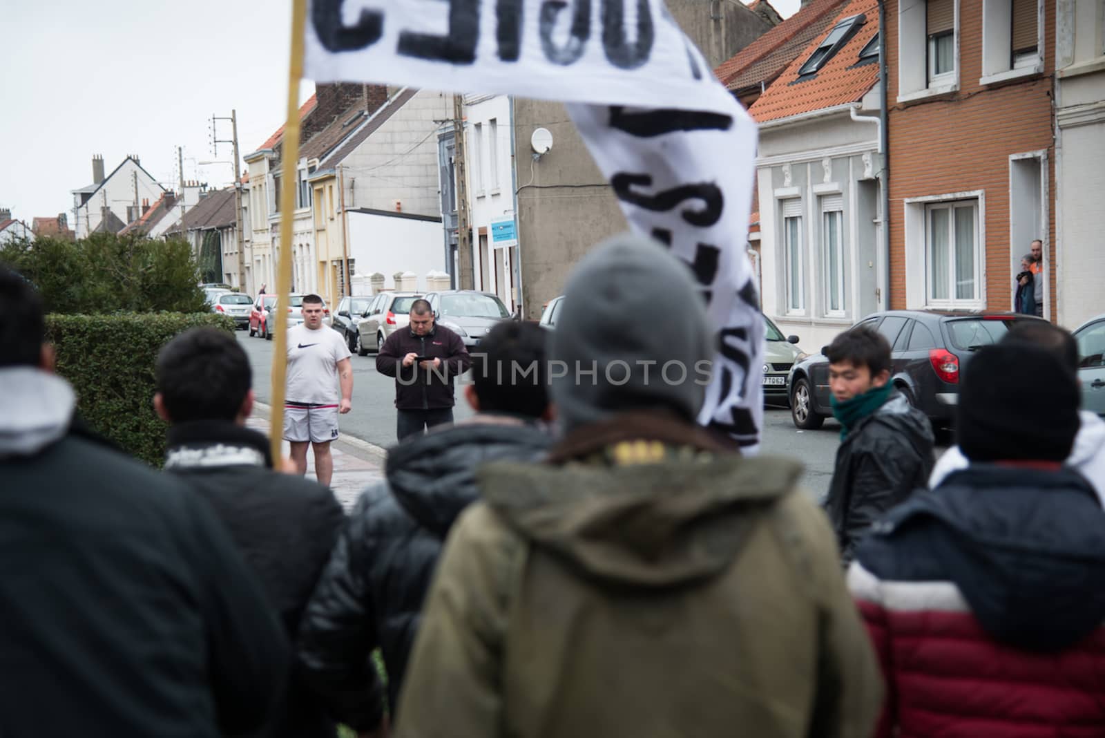 FRANCE, Calais: Two Calais inhabitants face a demonstration supporting migrants and refugees on January 23, 2016 in Calais, northern France. Those two men are about to get engaged in a fight with the demonstrators and migrants. 
