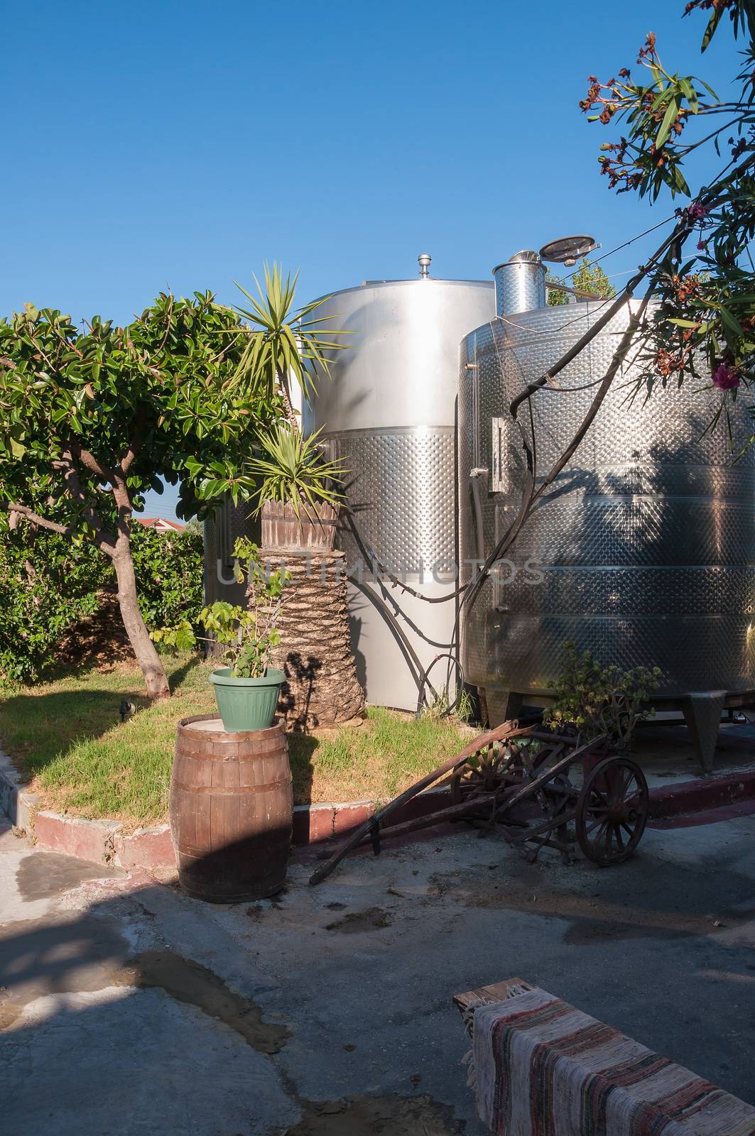 Steel silos for wine in a greek winery garden